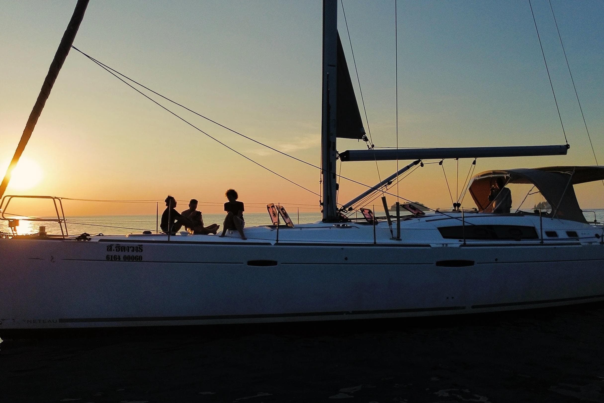Beneteau Oceanis 54 sailboat at sunset, 2013 model, with people enjoying the view.