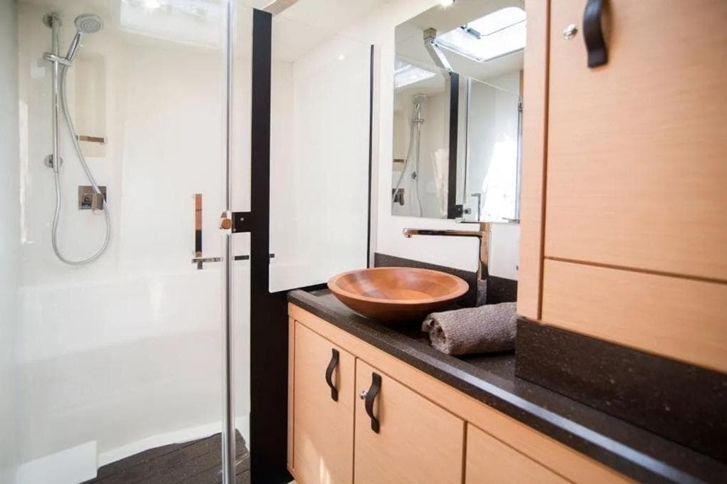 Luxurious bathroom in 2016 Jeanneau 64 yacht with modern fixtures and wooden accents.