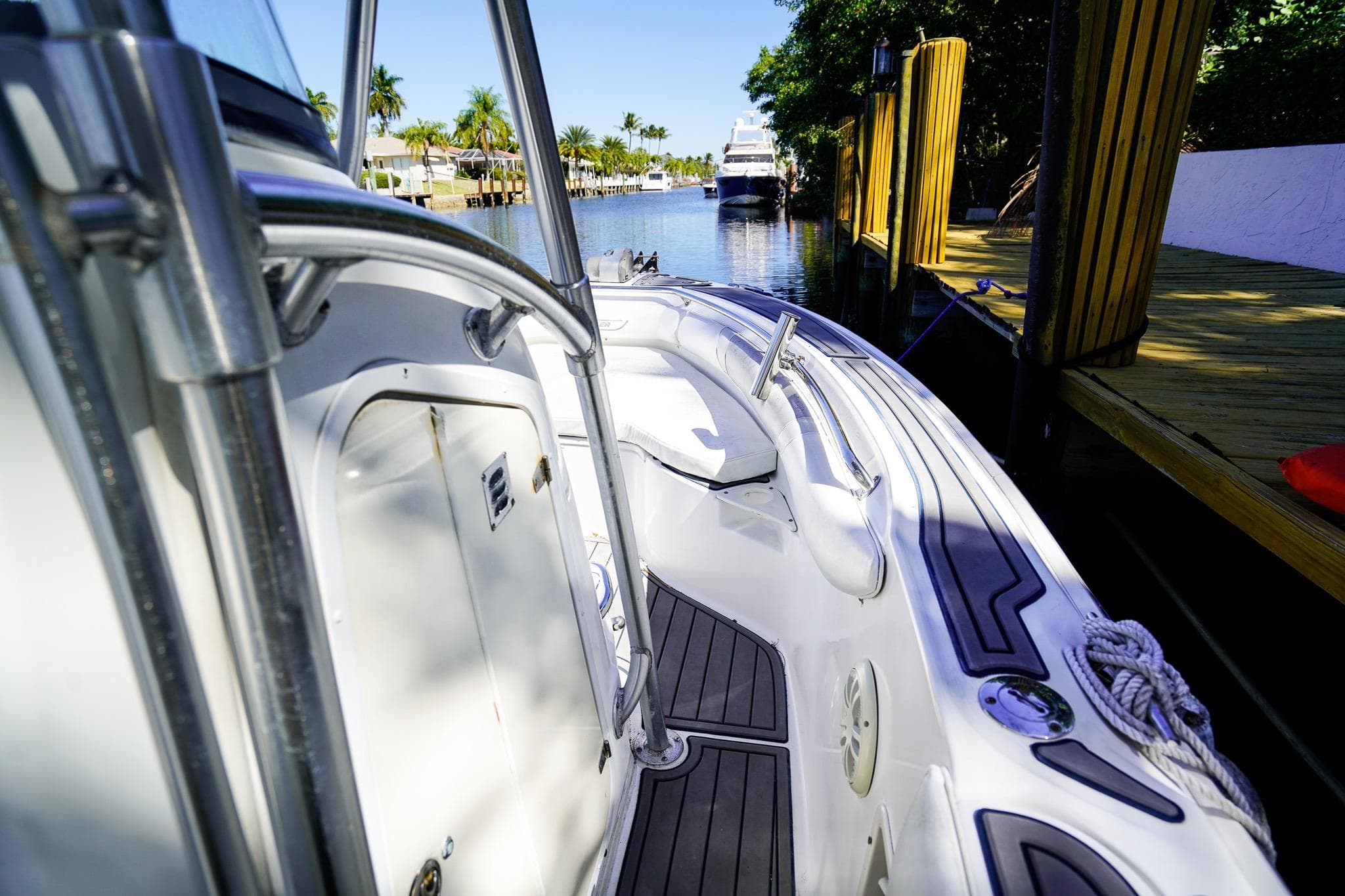 2004 Boston Whaler 240 Outrage boat docked in a scenic canal setting.