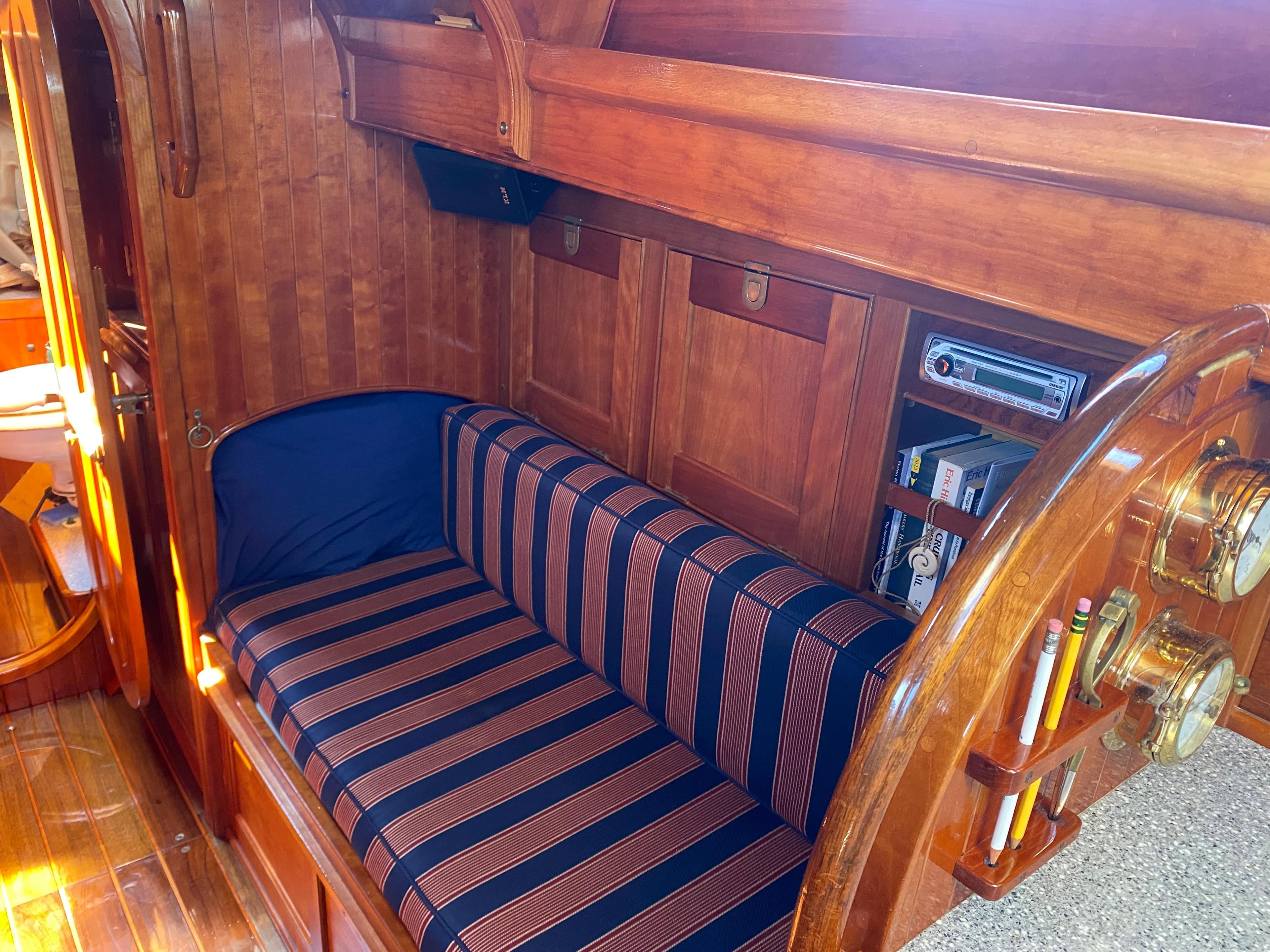 Interior of 2010 Laurent Giles Vertue Class Sloop with striped seating and wooden cabinetry.