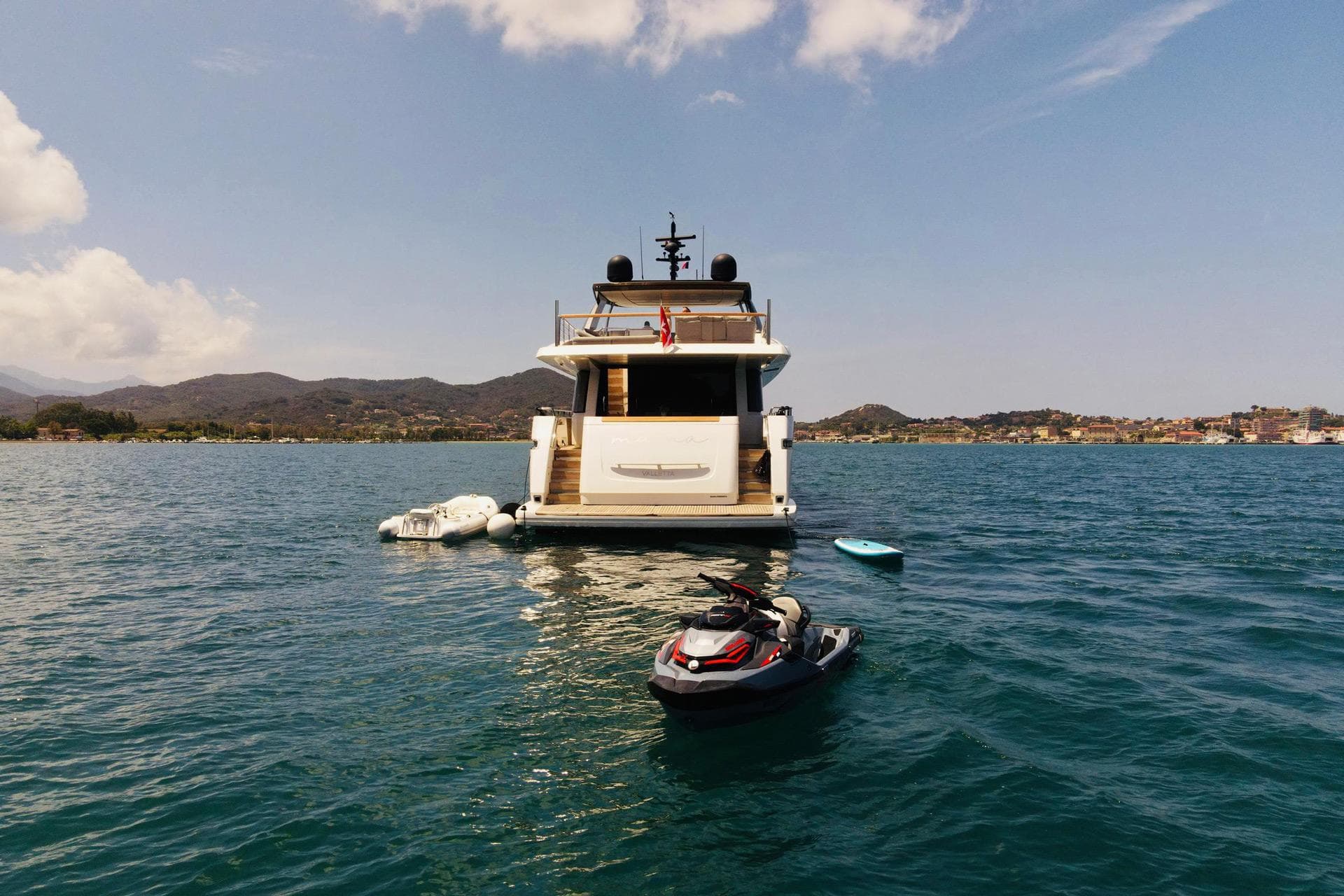 Sanlorenzo SL96 2016 yacht with jet ski and inflatables on calm water.