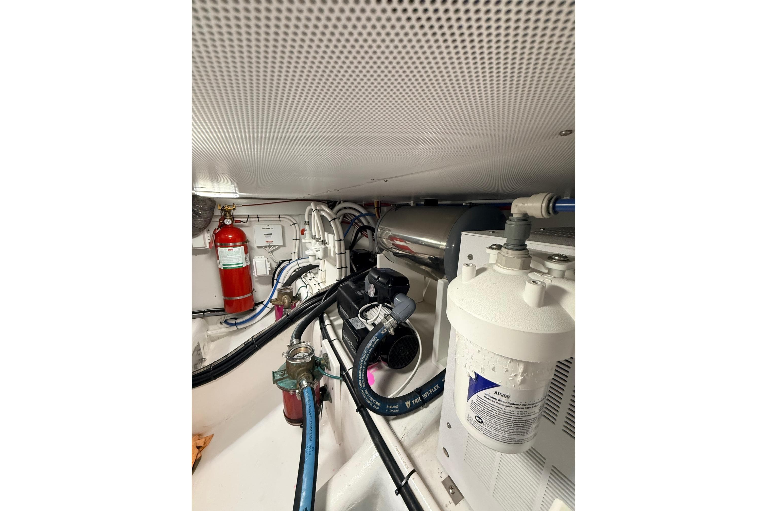 Engine room of 2025 Wesmac 42 boat with fire extinguisher and filtration system.