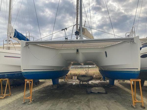 2011 Fountaine Pajot Lipari 41 catamaran on land, with blue hull and overcast sky.