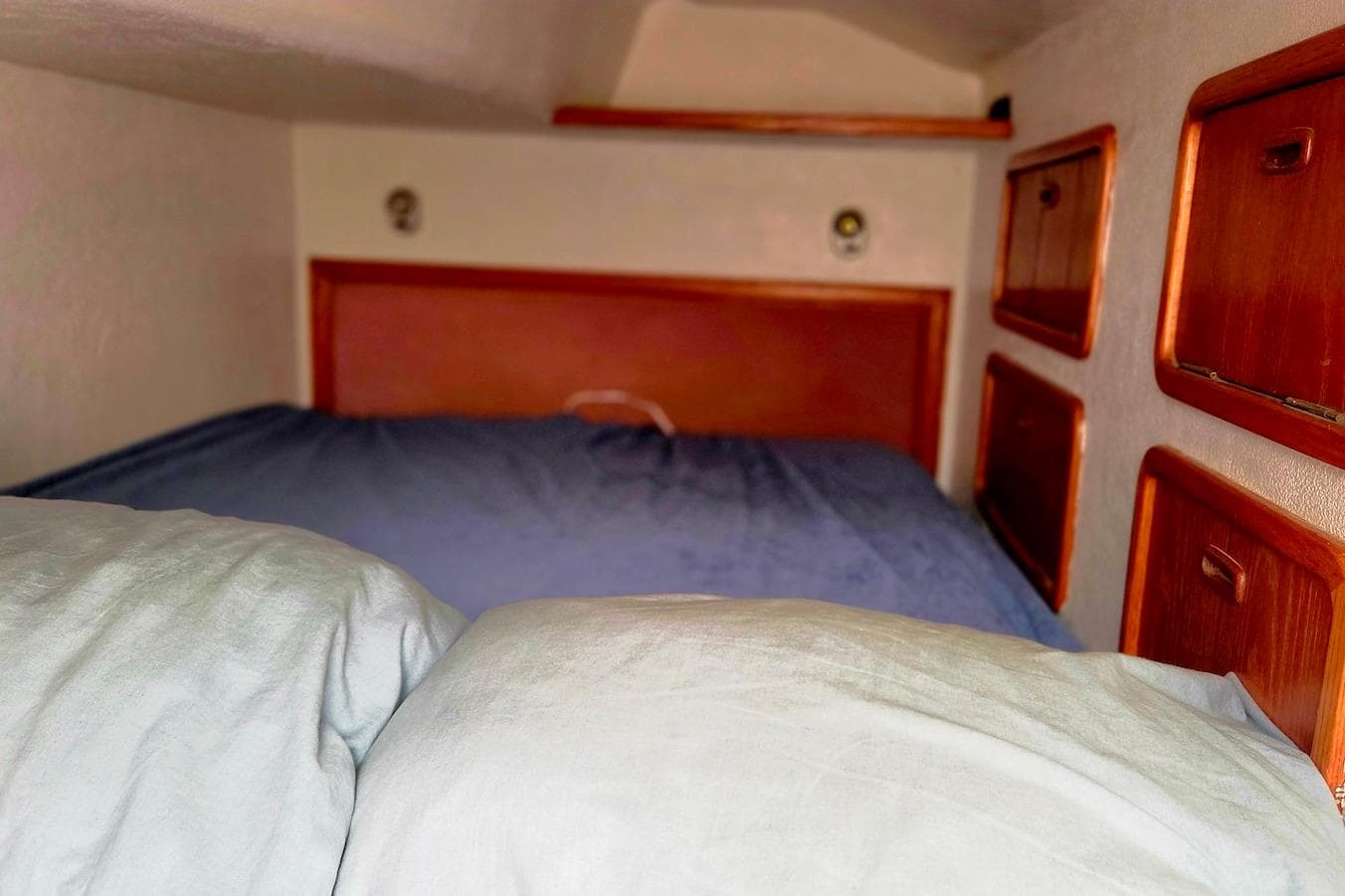Cozy cabin interior of 1995 Catamaran St. Francis 43 with wooden storage compartments.