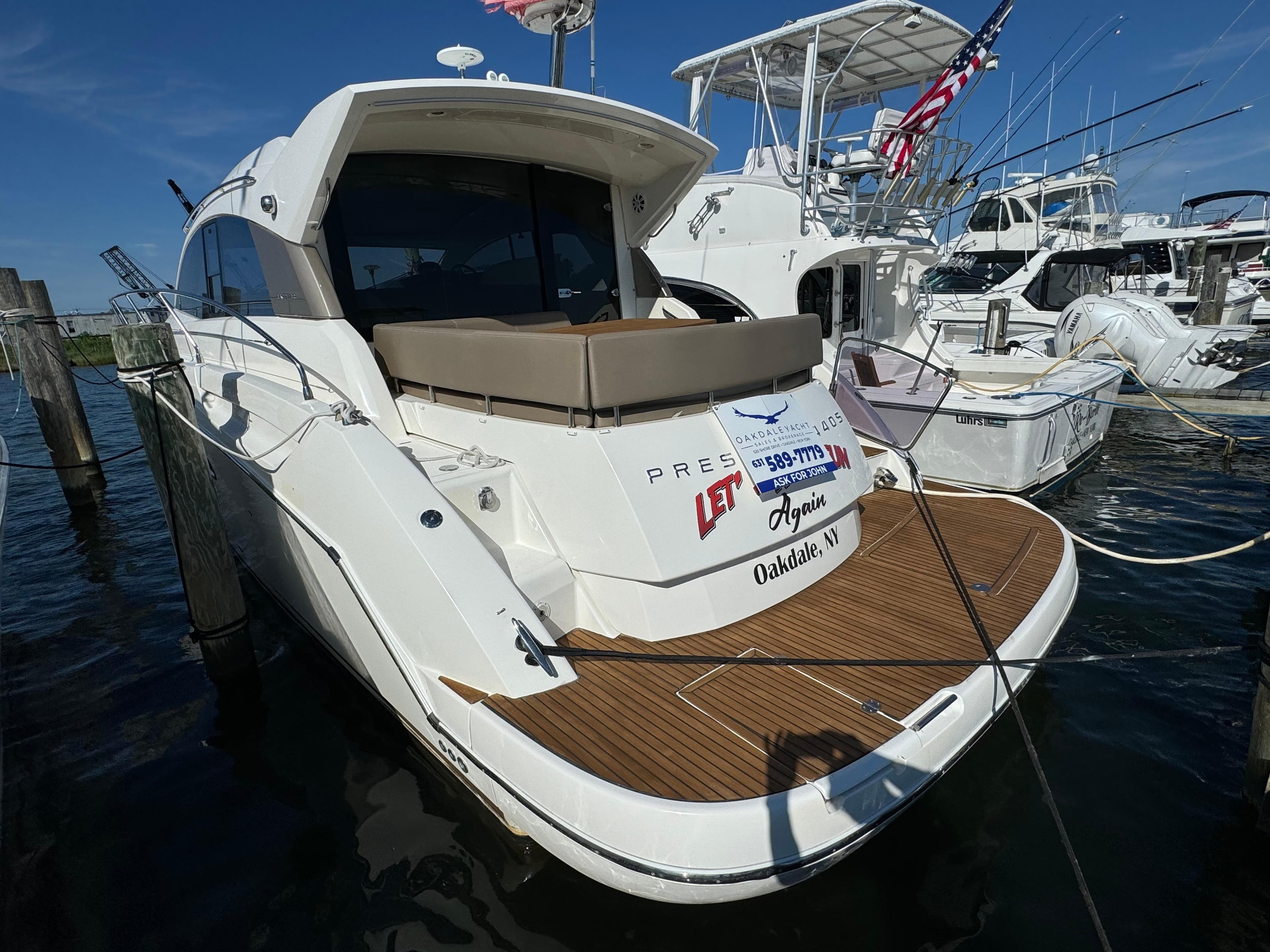 2012 Prestige 440 S yacht docked at marina, rear view with wooden deck.