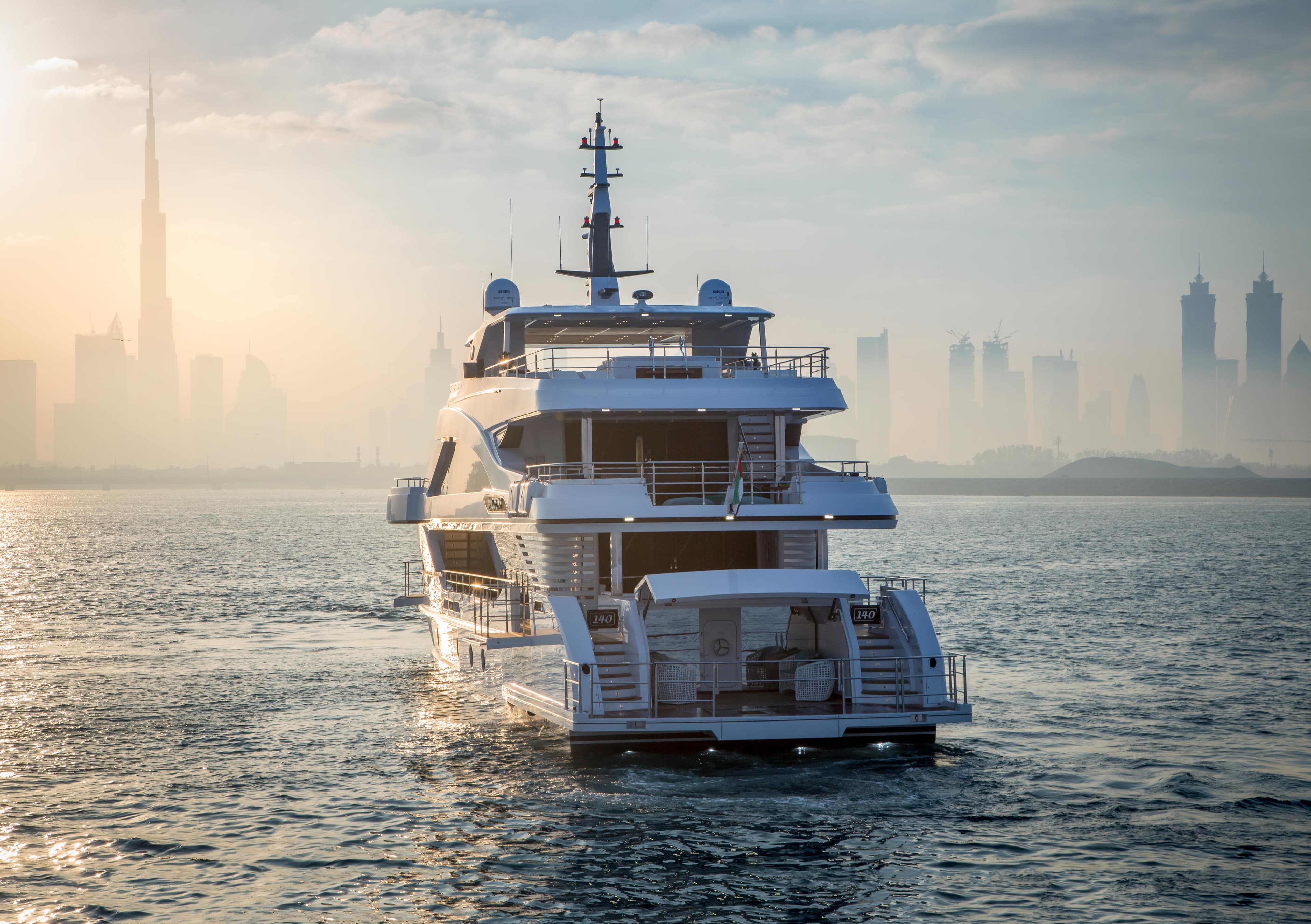 Majesty 140 yacht cruising near a city skyline at sunset, 2025 model.