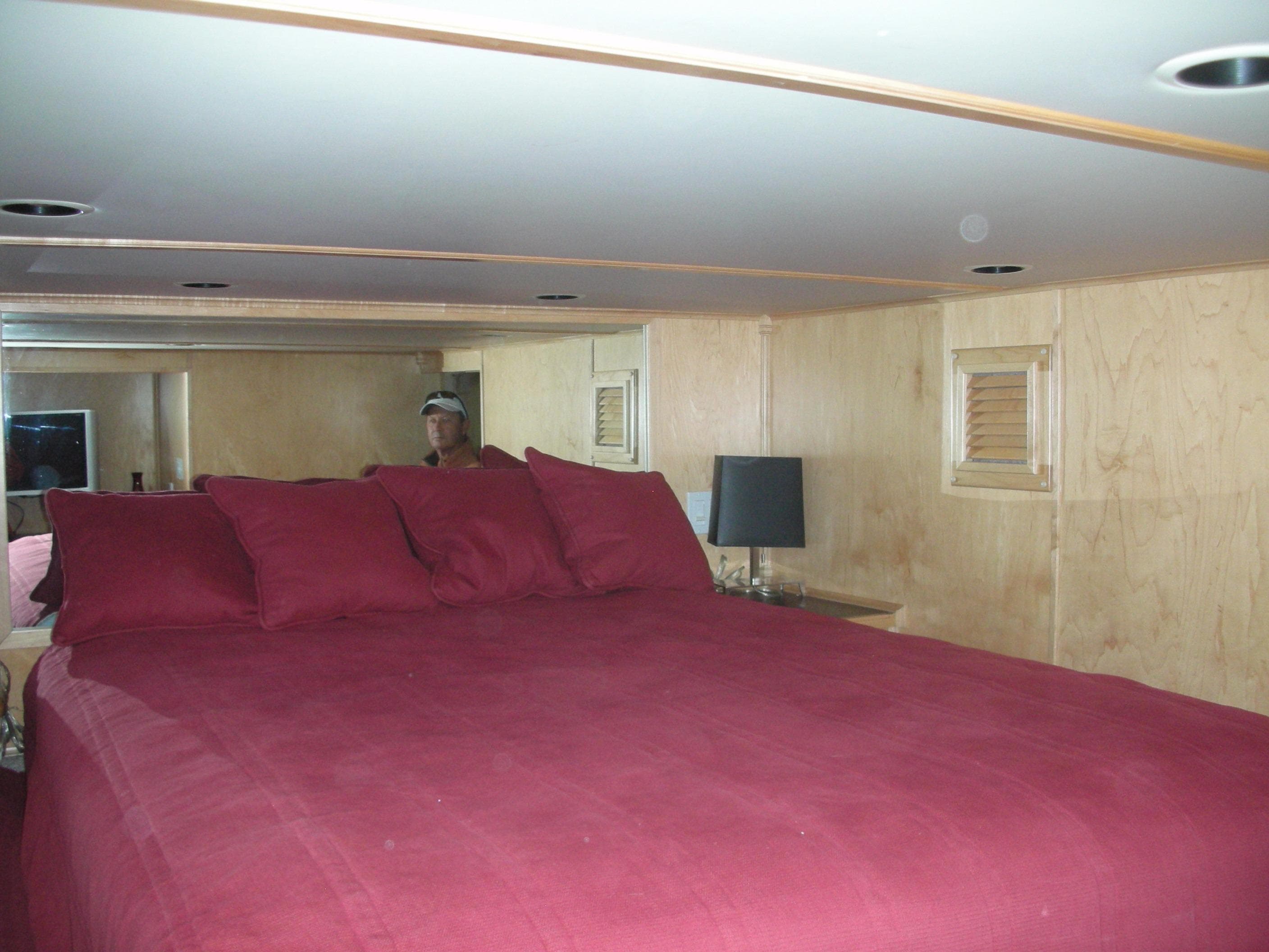 Sumerset Seas The Day Trip 11 2006 houseboat bedroom with red bedding and wooden walls.