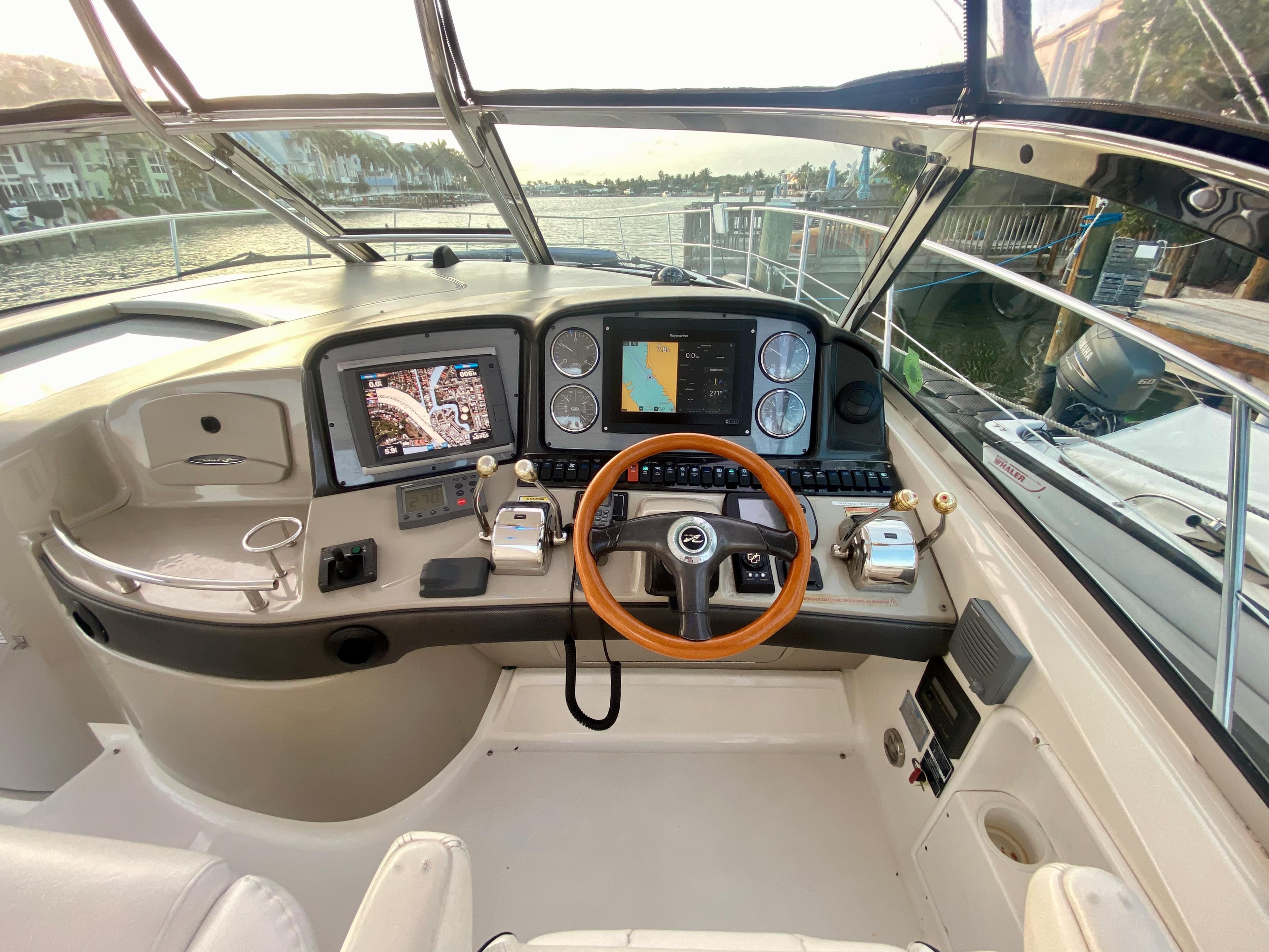 Helm of 2005 Sea Ray 420 Sundancer with navigation screens and wooden steering wheel.