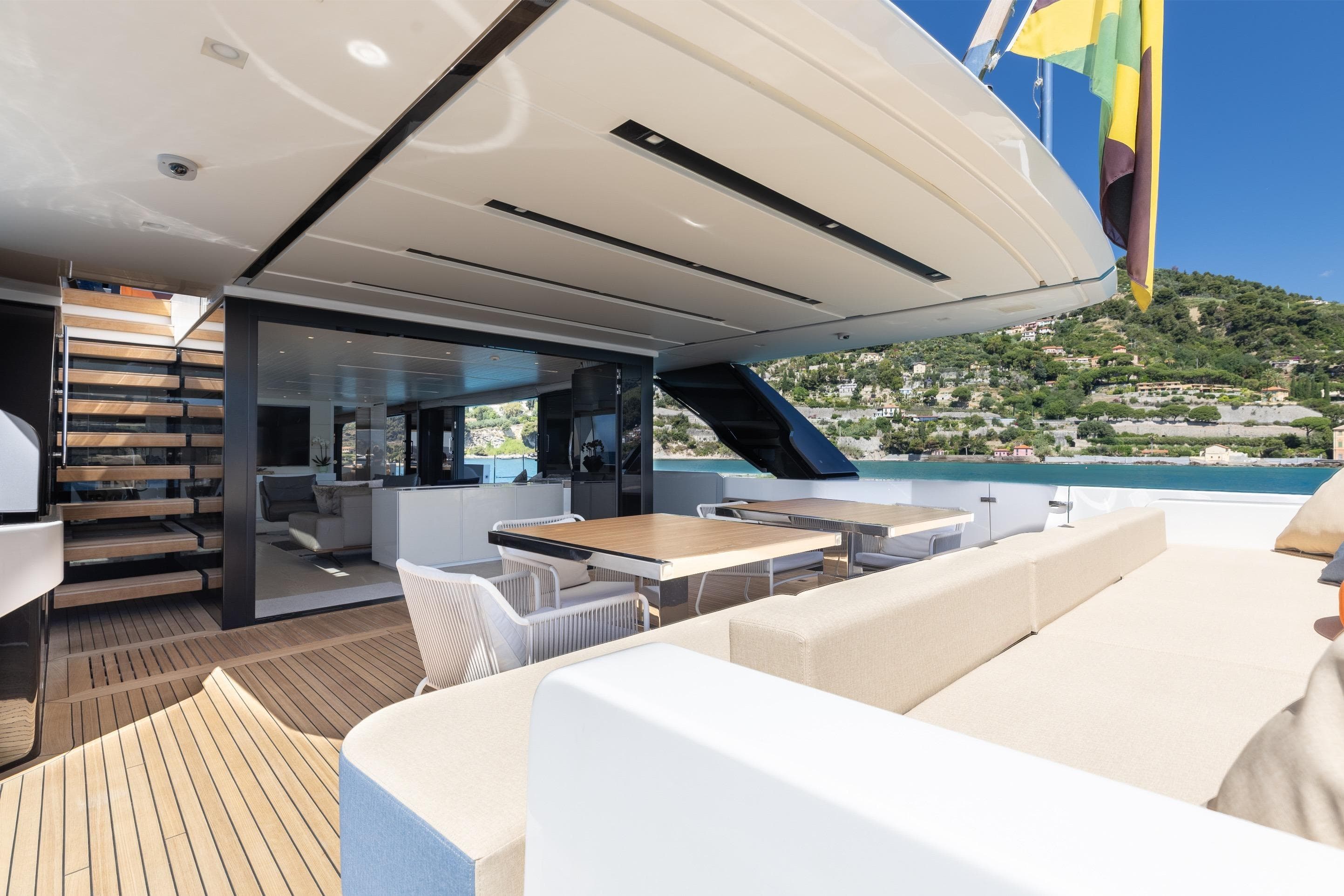 Luxurious 2022 Sanlorenzo SL106A yacht deck with elegant seating and scenic coastal view.
