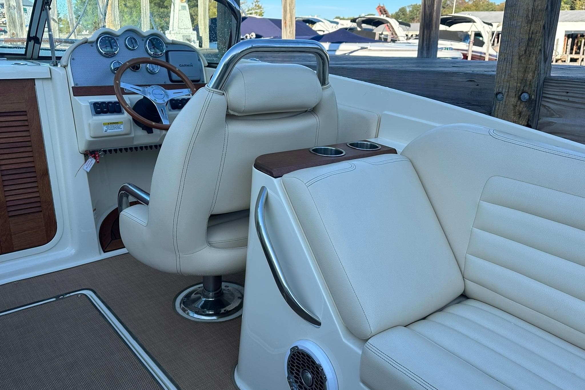 2013 Chris-Craft Corsair 25 boat interior with leather seating and wooden dashboard.