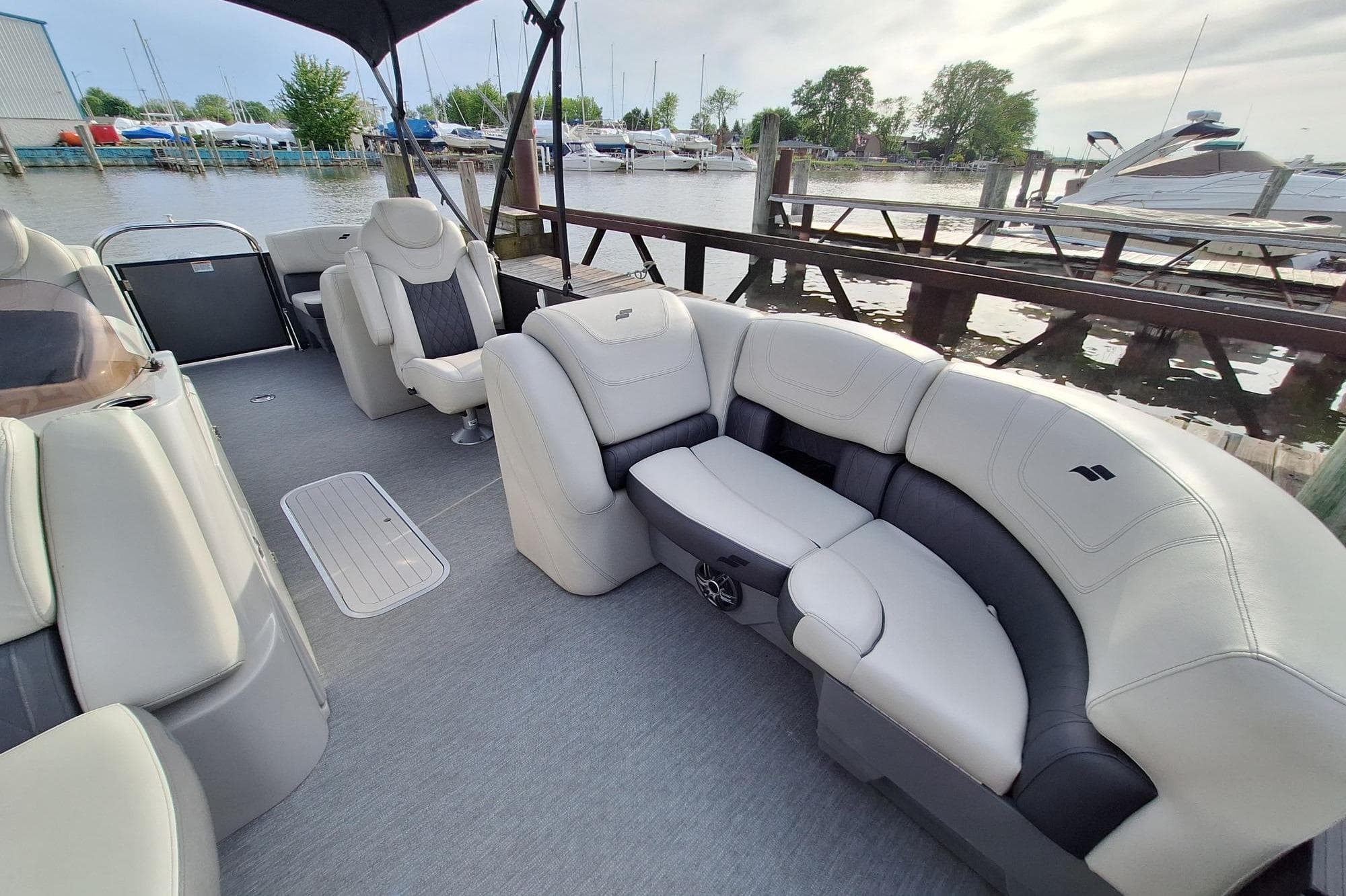 Luxurious 2022 Starcraft SLS 1 pontoon boat interior with plush seating at marina.