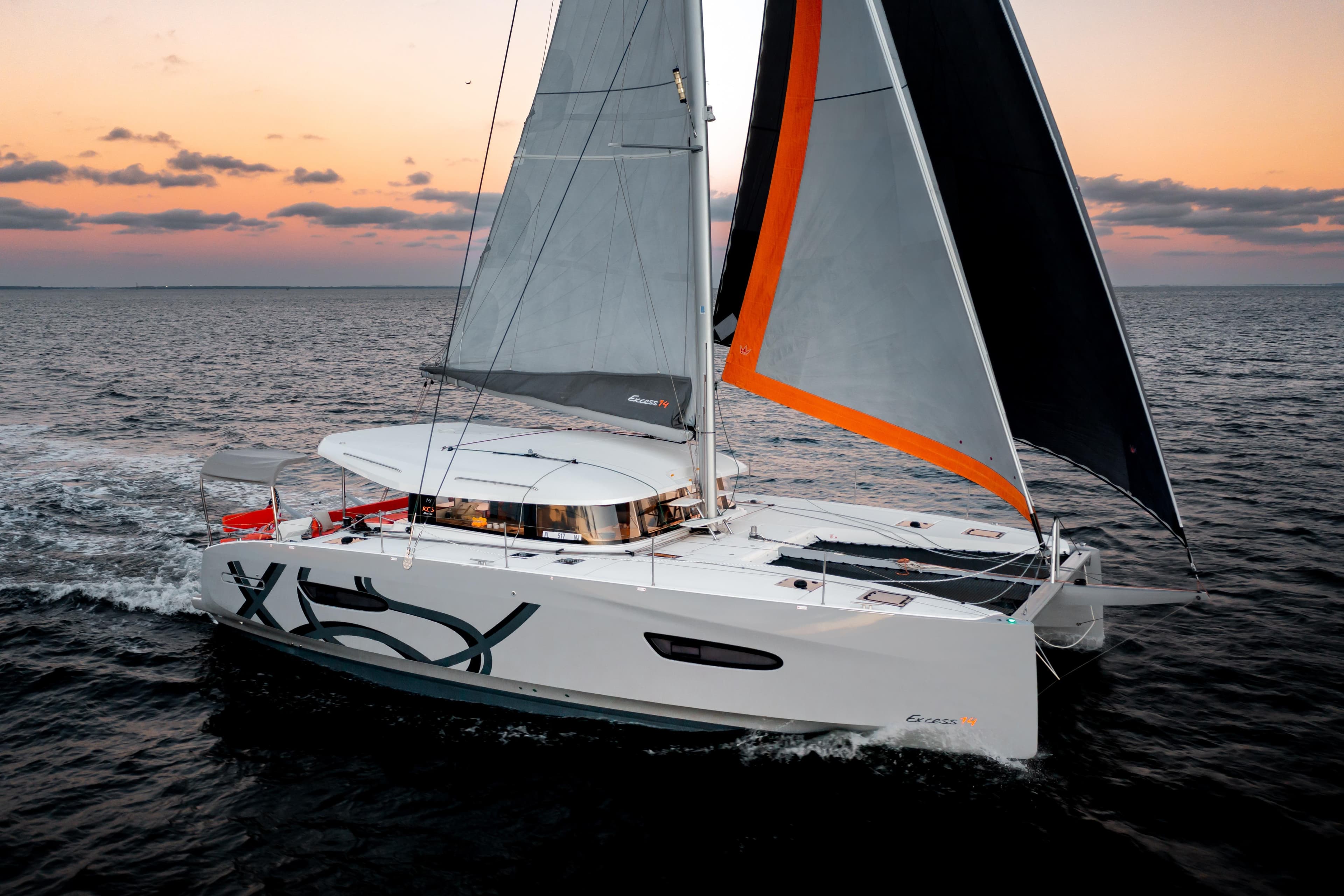 Sailing catamaran Excess EXCESS 14, 2026 model, at sunset on open sea.
