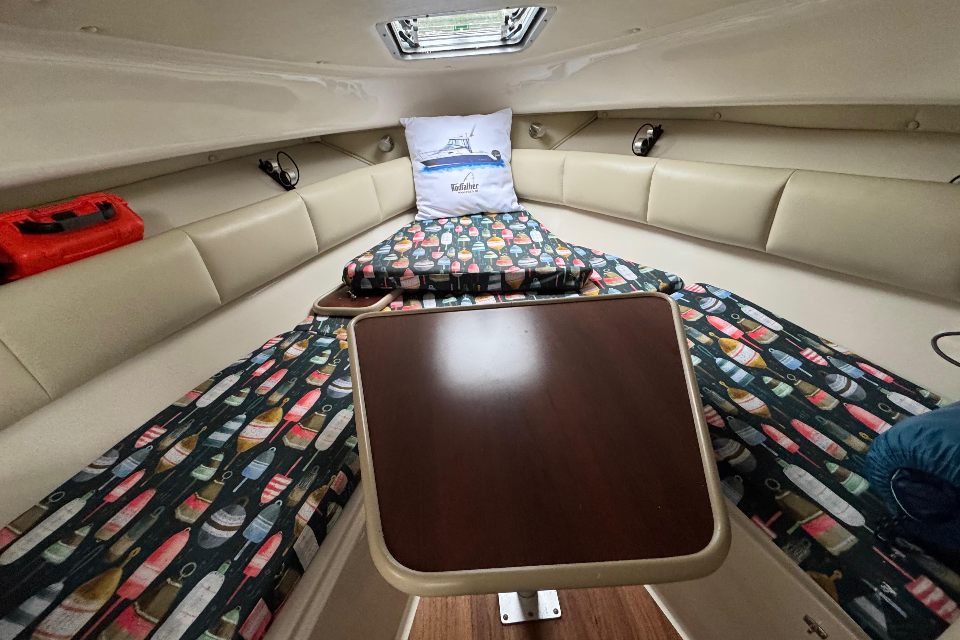 2014 Robalo R265 Walkaround cabin interior with colorful patterned cushions and wooden table.
