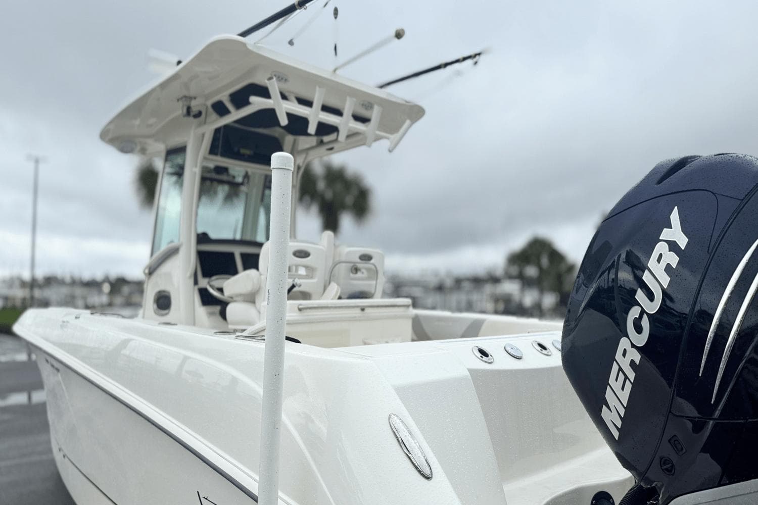 2015 Boston Whaler 280 Outrage boat with Mercury engine, docked on a cloudy day.