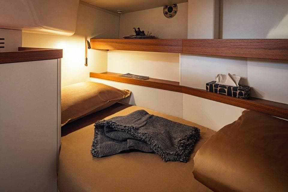 Cozy cabin interior of 2023 Pegasus 50 yacht with warm lighting and wooden accents.