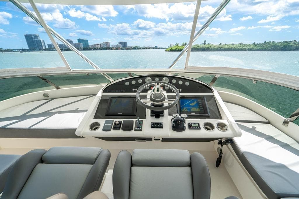 Cockpit view of 2020 Fairline 68 yacht with modern navigation equipment and city skyline.