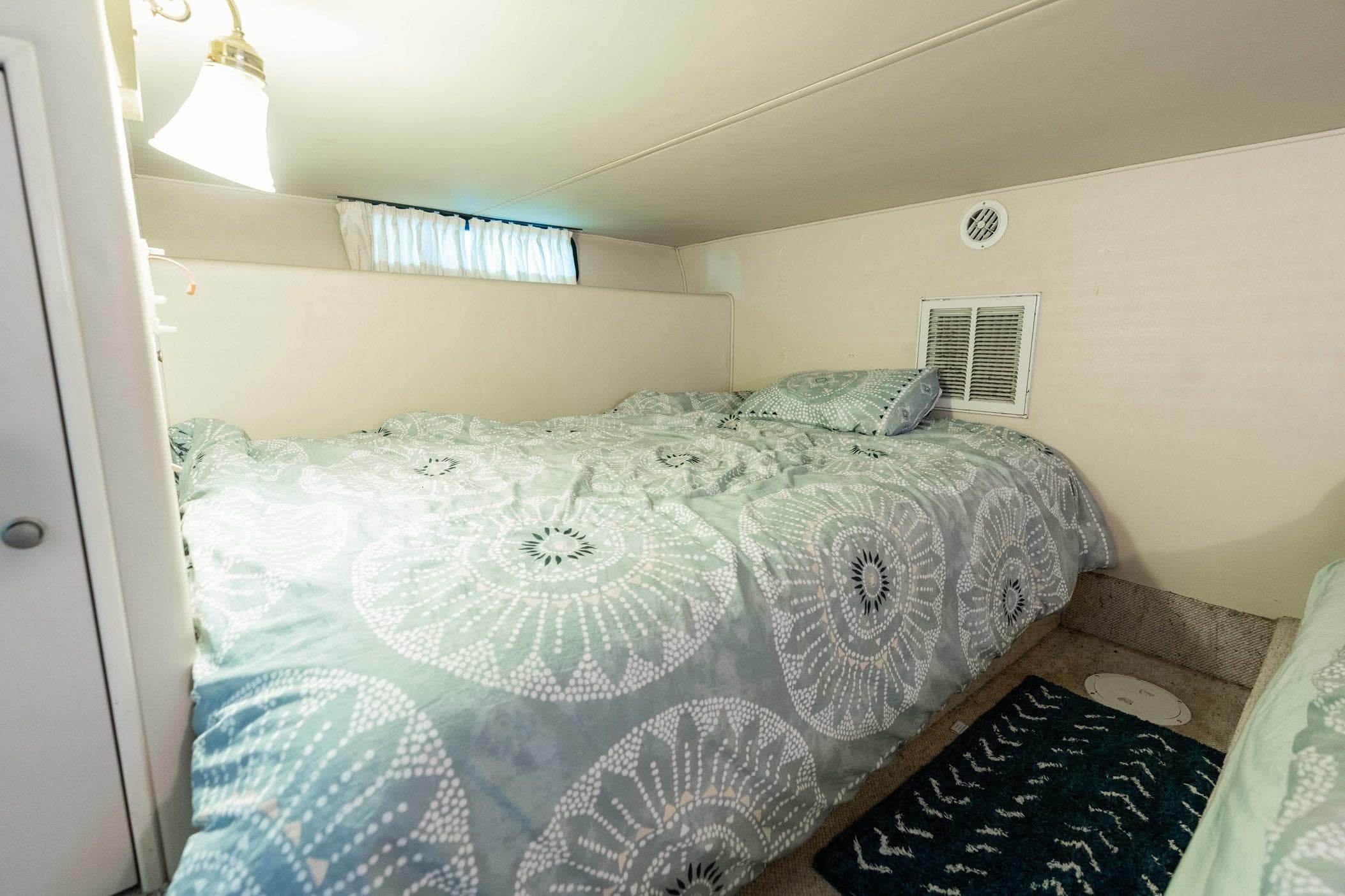 Cozy bedroom in 2001 Harbor Master 520 Coastal boat with patterned bedding.