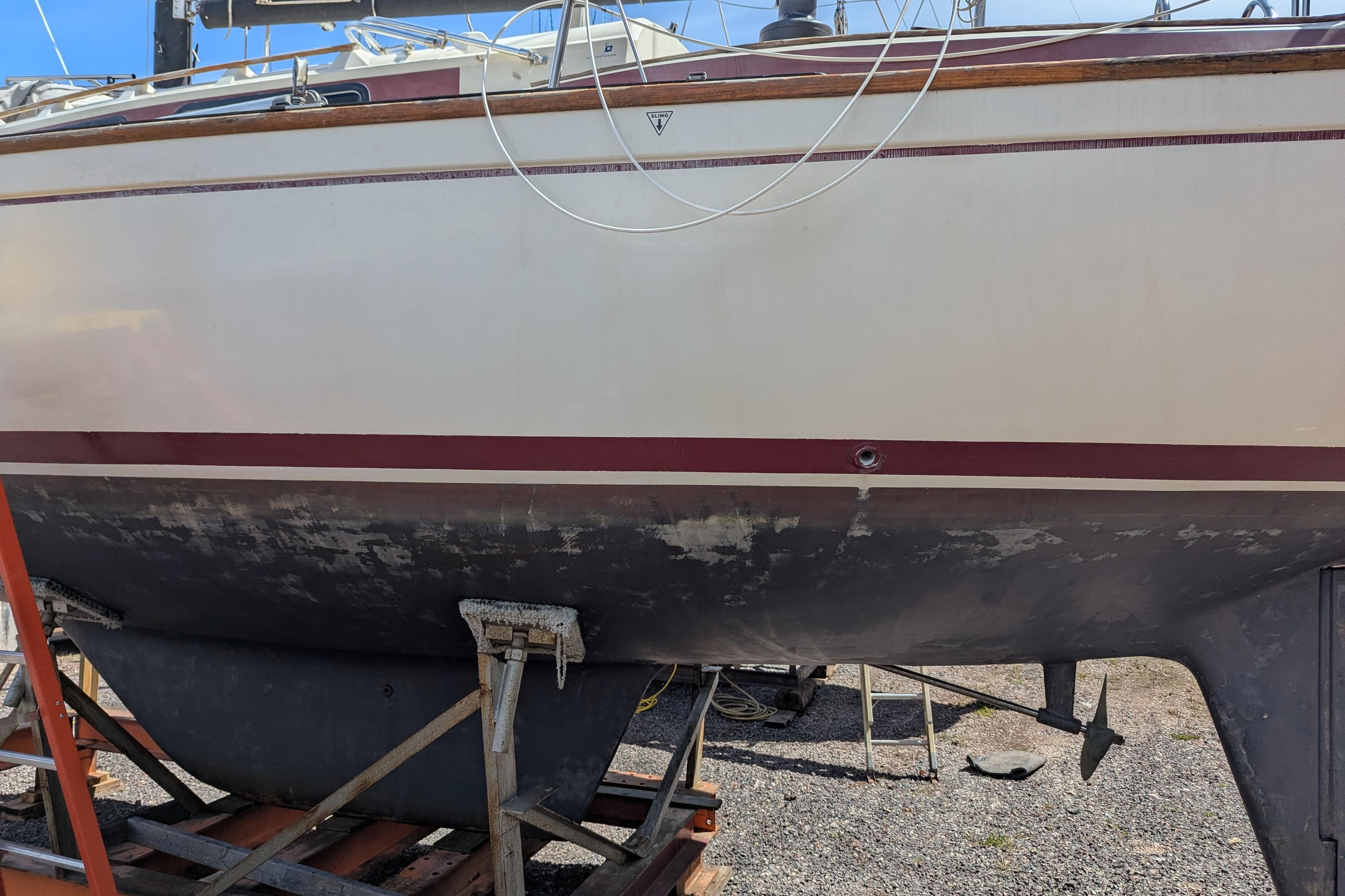 1982 Pearson 323 sailboat on dry dock, showing hull and keel details.
