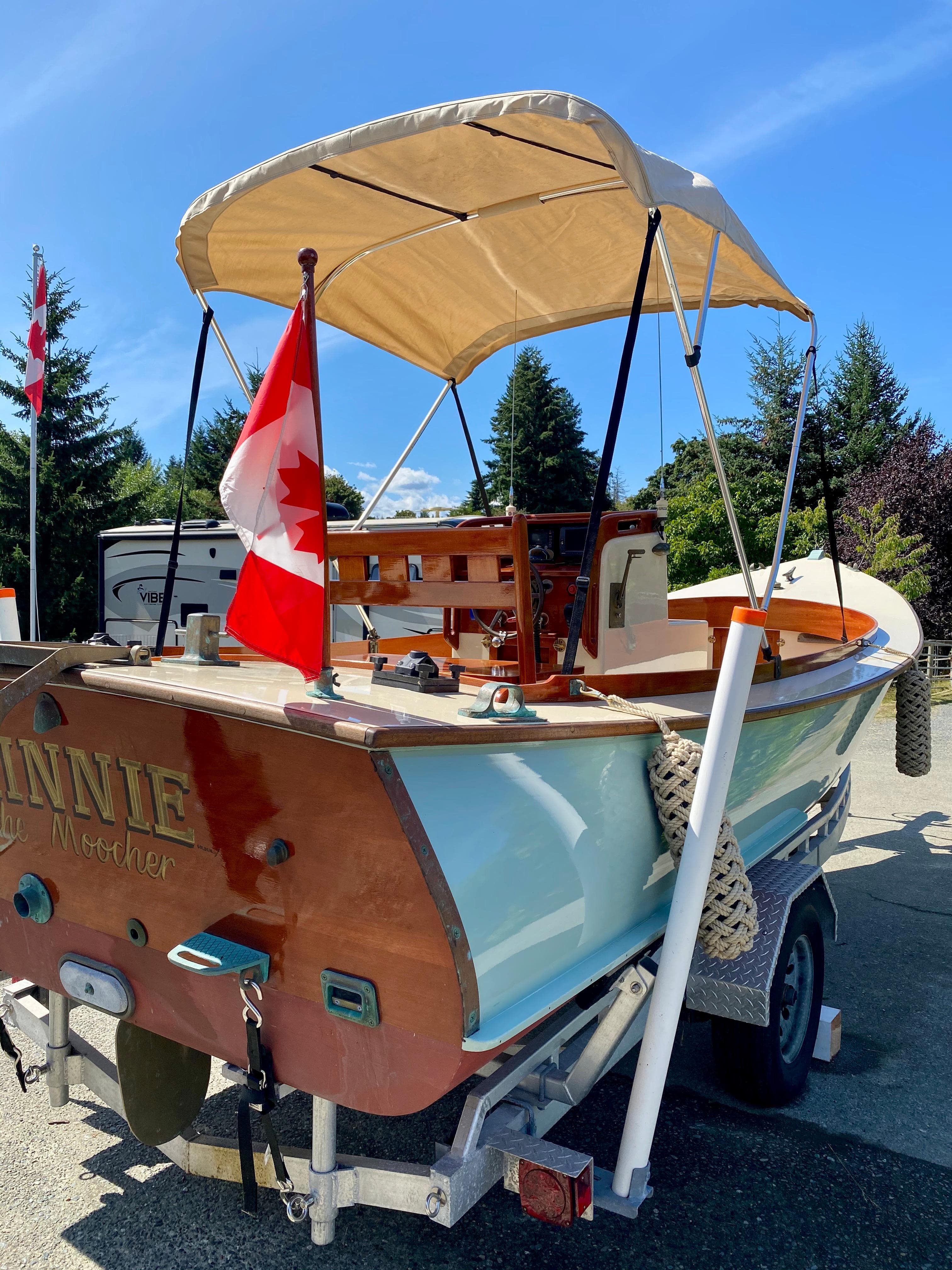 2014 Stimson Ocean Pointer Launch boat with canopy and Canadian flag on trailer.