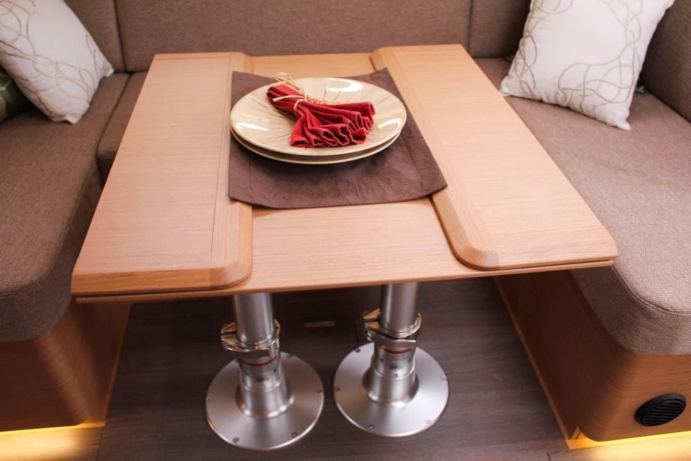 Interior of 2025 Jeanneau Sun Odyssey 440 yacht with elegant wooden table setting.