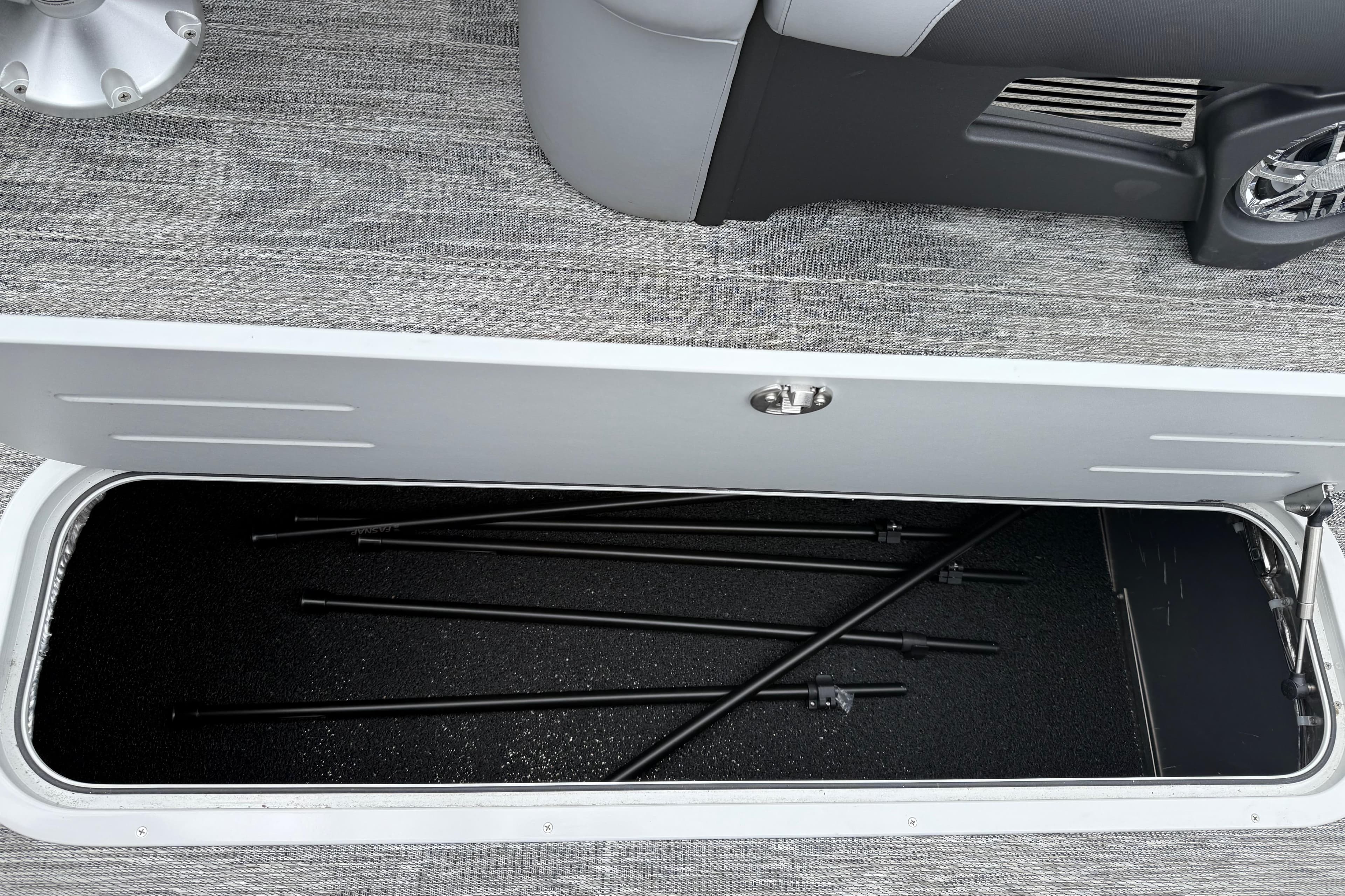 Storage compartment in 2026 Avalon Excalibur LTD Quad Lounge Windshield boat, featuring sleek interior design.