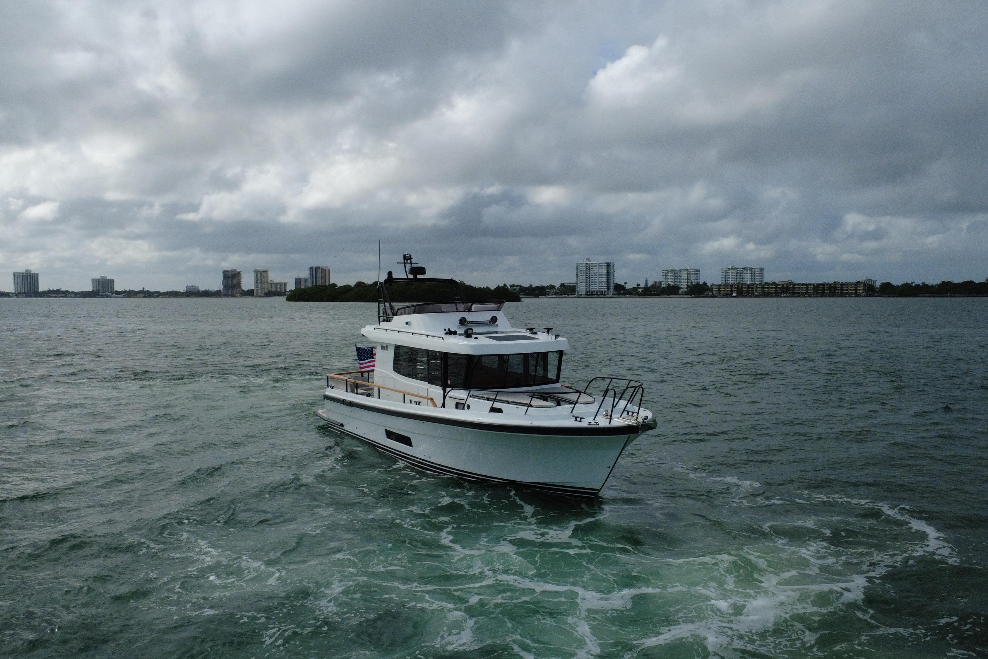 2026 Targa 41 boat cruising on a cloudy day near city skyline.