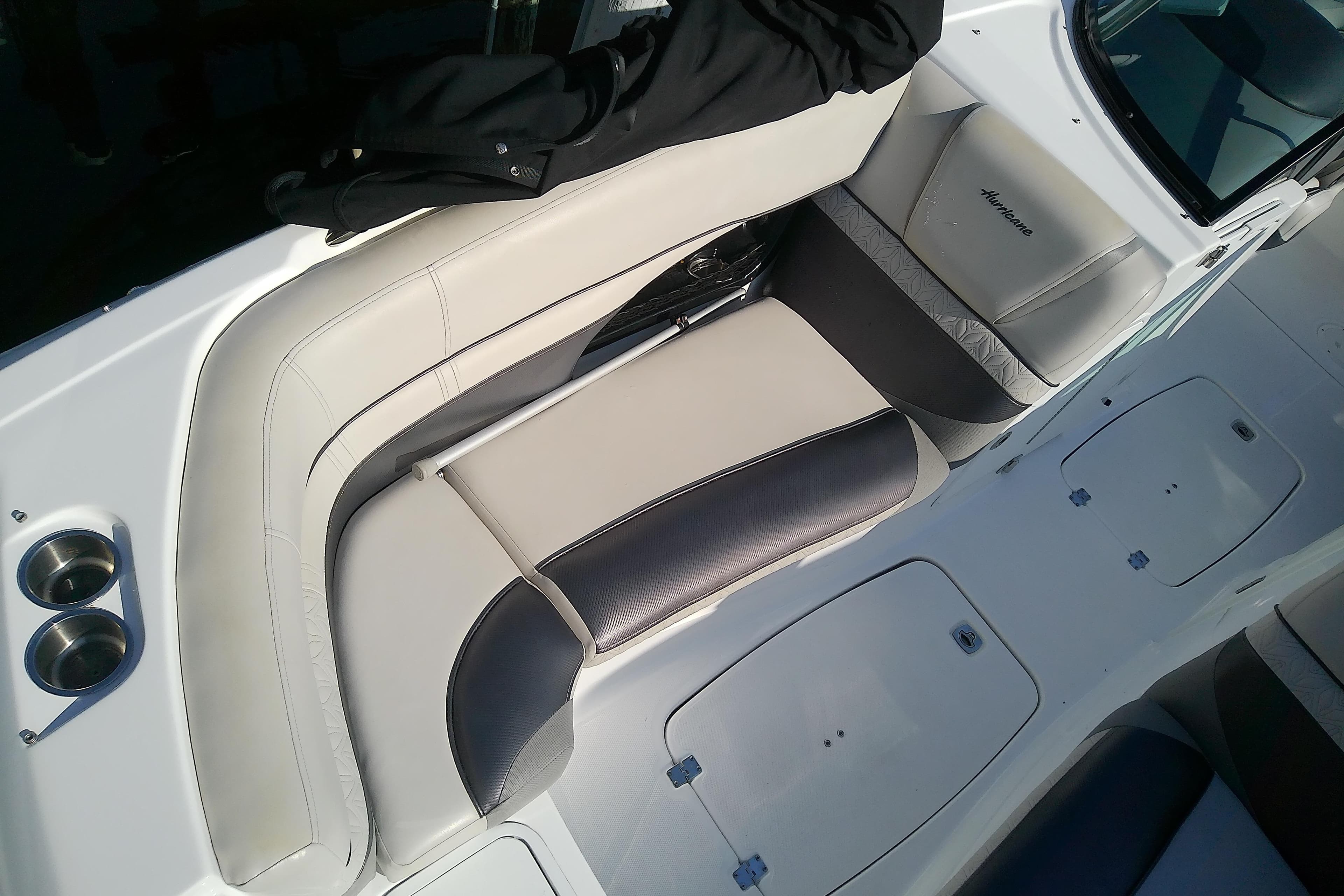 2021 Hurricane SunDeck 2410 OB boat interior with cushioned seating and cup holders.
