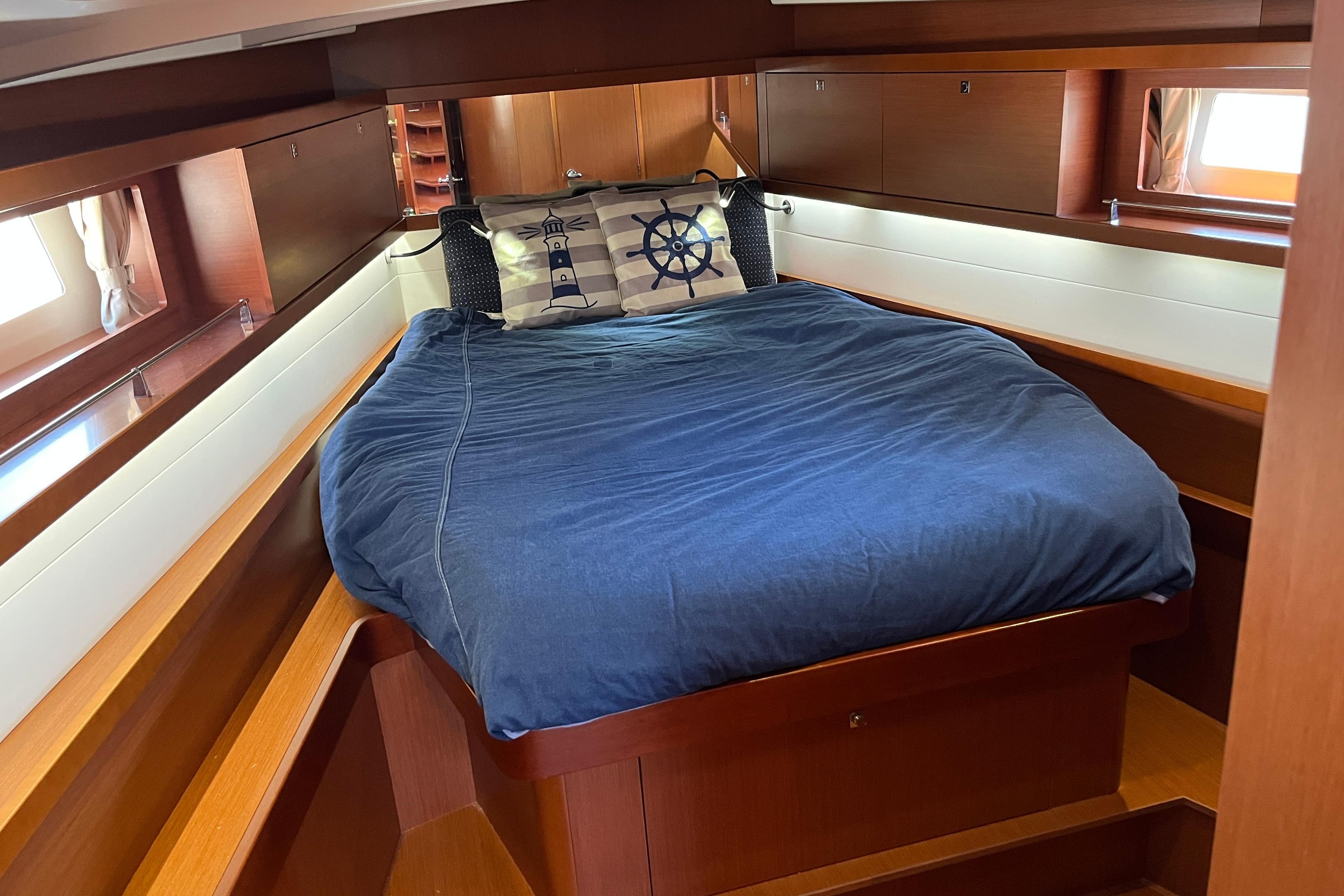 Cabin interior of 2014 Beneteau Oceanis 45 yacht with cozy bed and nautical decor.