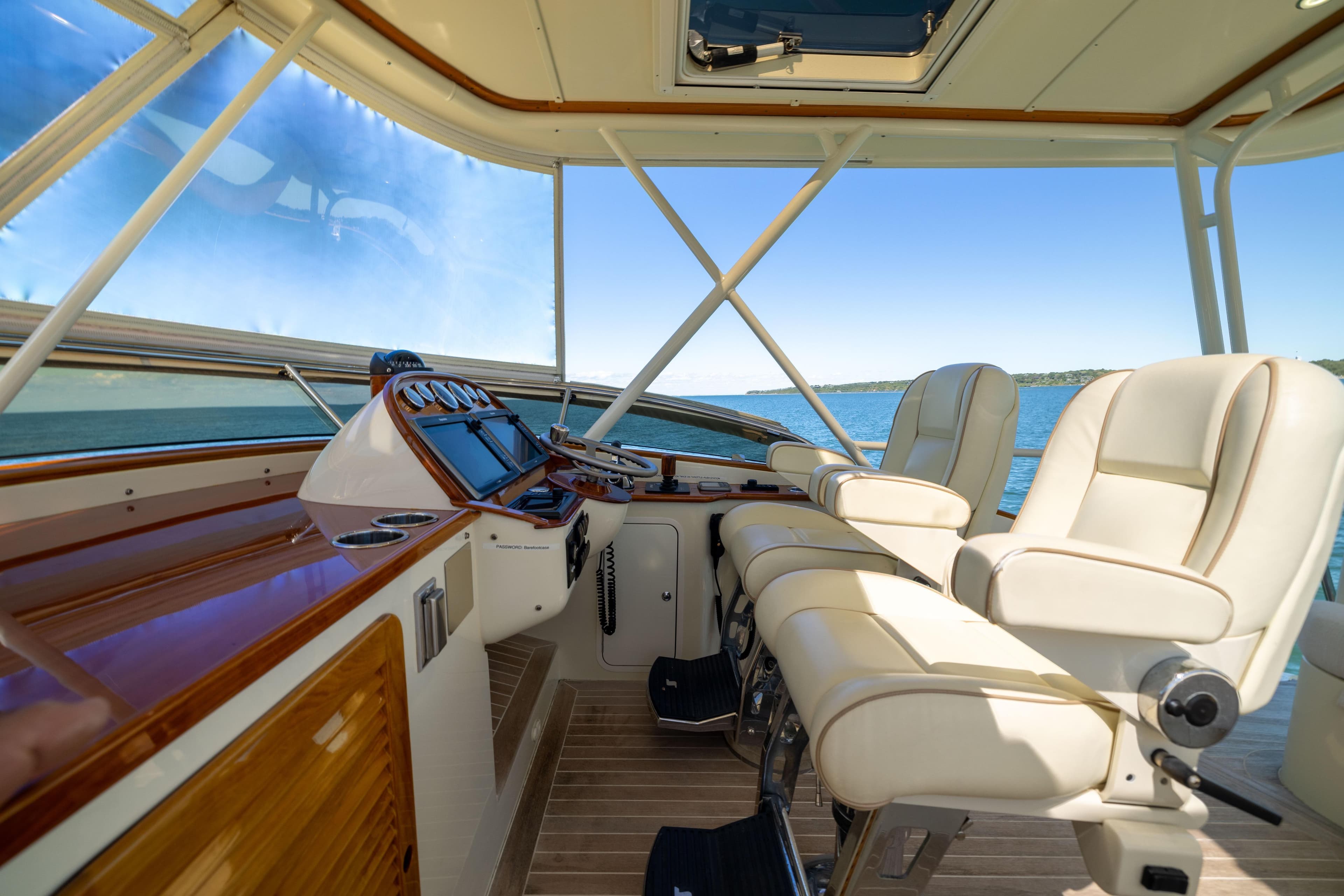 Flybridge interior of 2014 Hinckley Talaria 48, featuring luxurious seating and navigation controls.