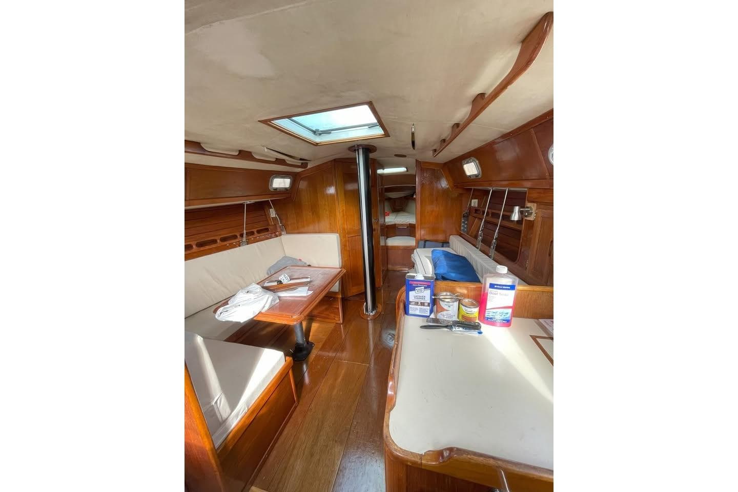 Interior of 1986 Ericson 381 sailboat, featuring wooden furnishings and cozy seating area.
