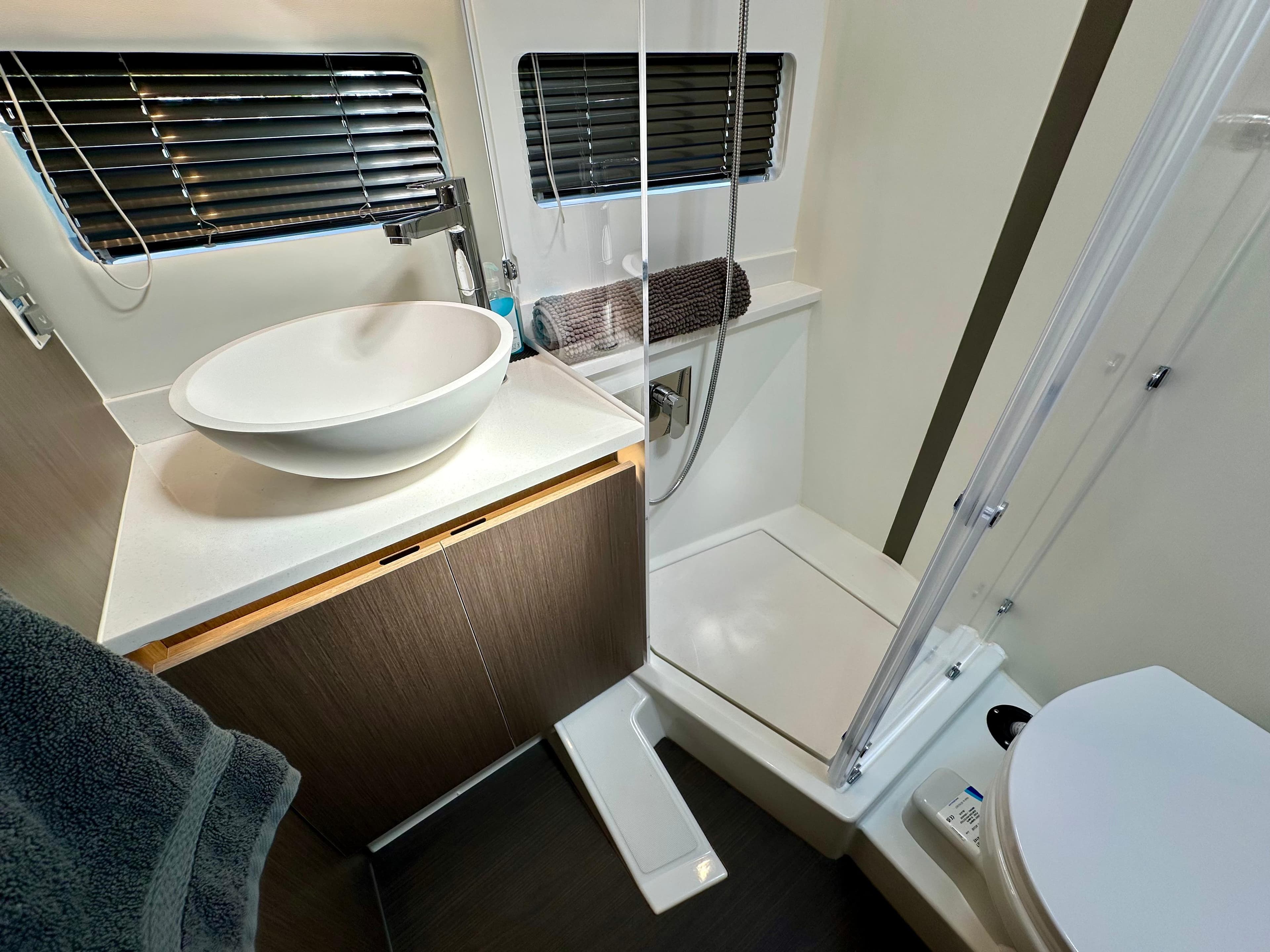 Modern bathroom in 2024 Jeanneau Merry Fisher 1295 Flybridge with sink, shower, and toilet.