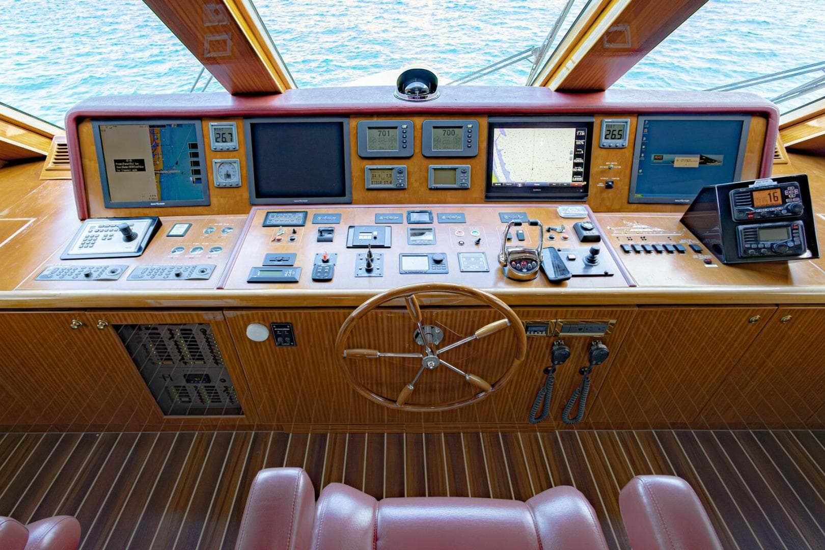2009 Hargrave Enclosed Bridge yacht helm with navigation controls and wooden steering wheel.