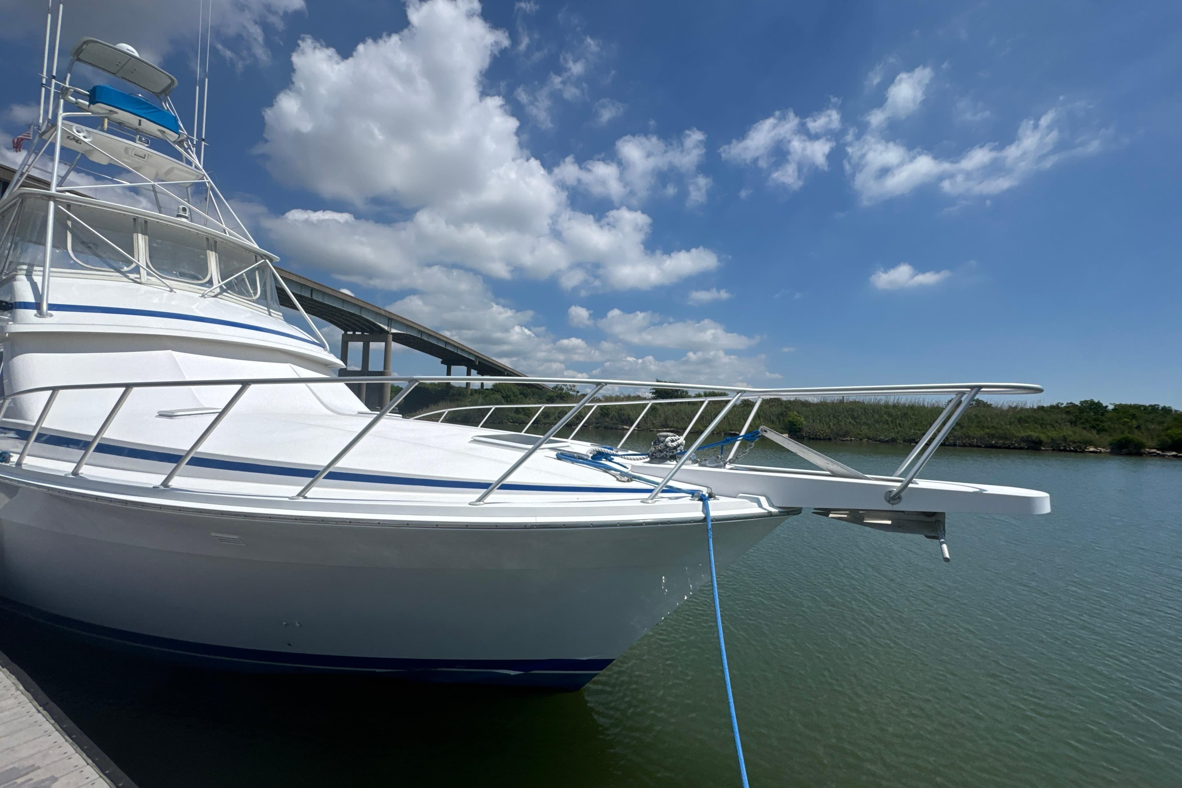 1997 Bertram 54 Convertible yacht docked under a clear blue sky.