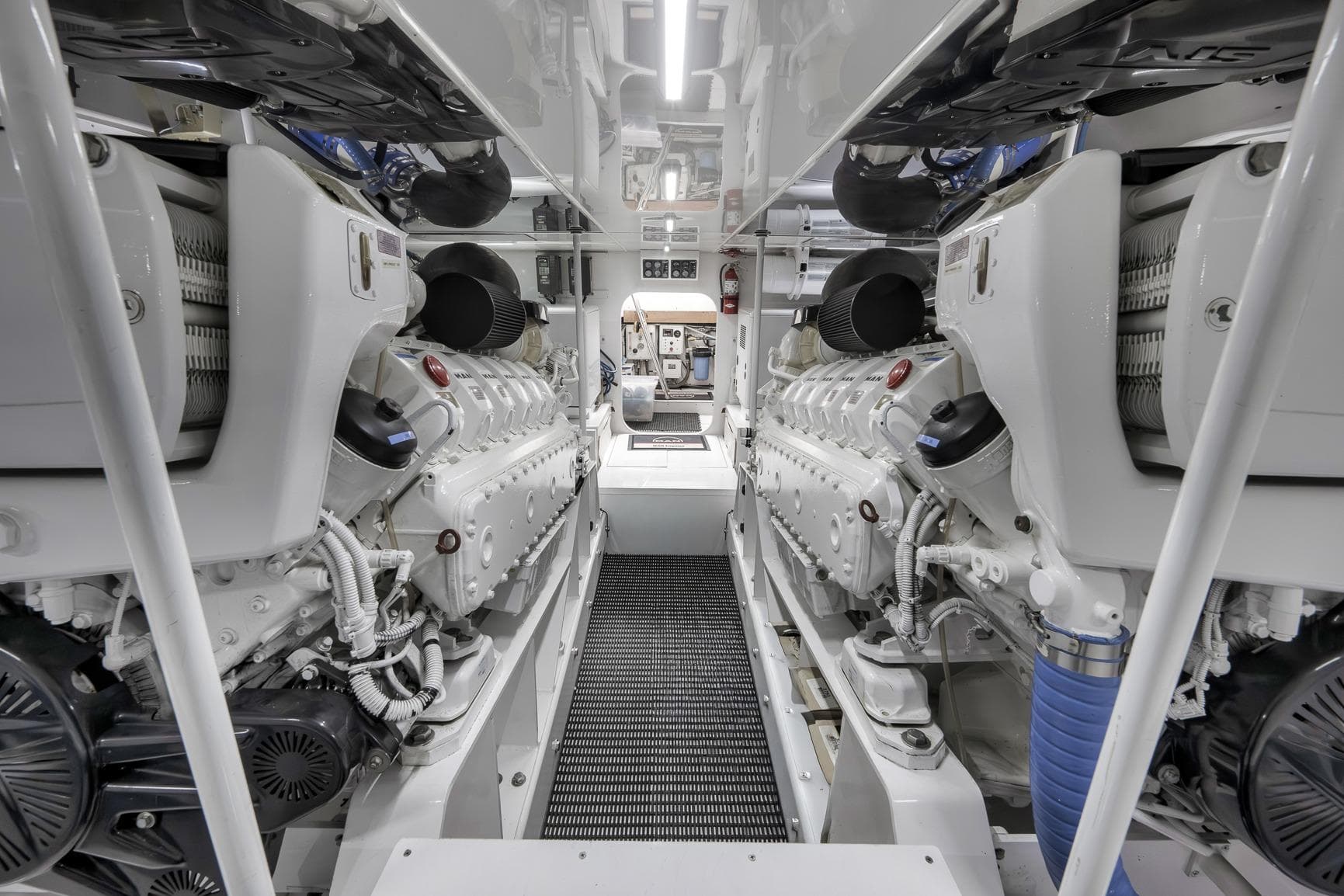 Engine room of 1999 Hines-Farley SPORTFISHERMAN yacht, showcasing dual engines and mechanical details.