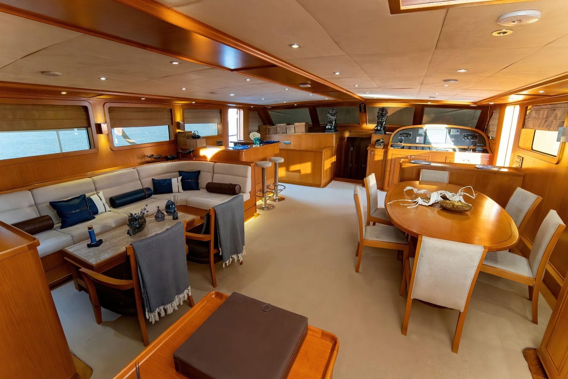 Luxurious yacht interior with elegant wood finishes, dining area, and comfortable seating, Custom 134 model, 2015.