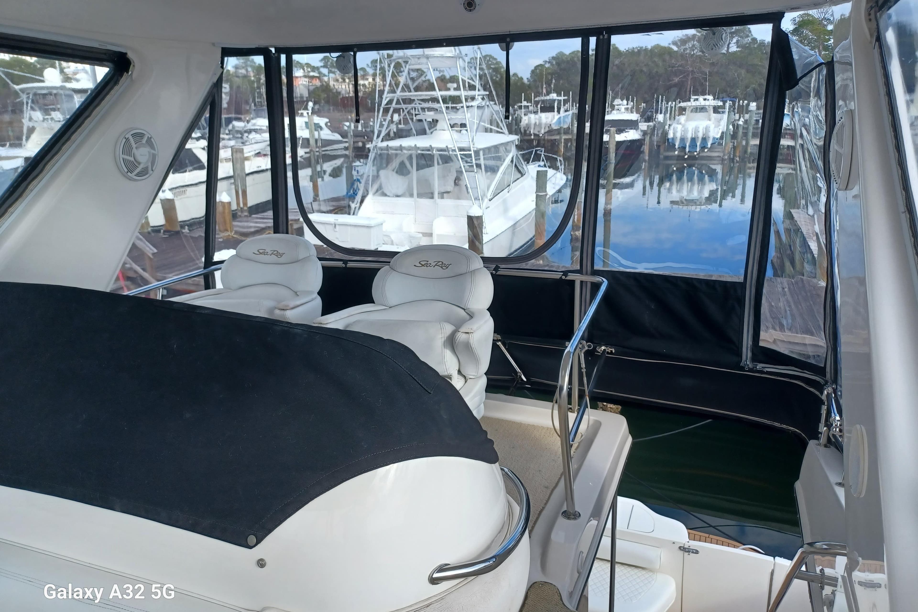 1999 Sea Ray 480 Sedan Bridge interior with marina view, featuring plush seating.