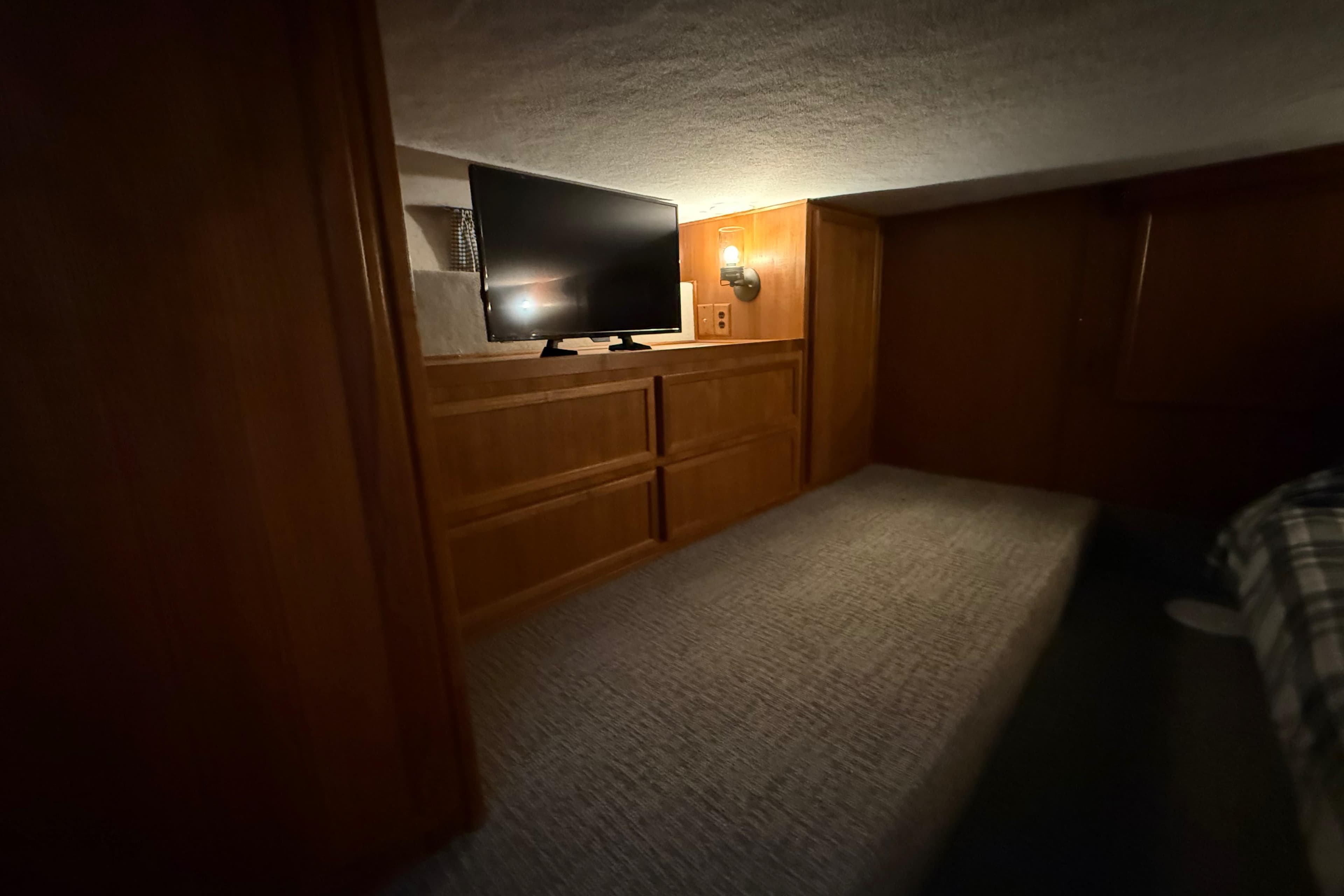 Cozy interior of 1995 Harbor Master 52 Wide Body with TV and wooden cabinetry.