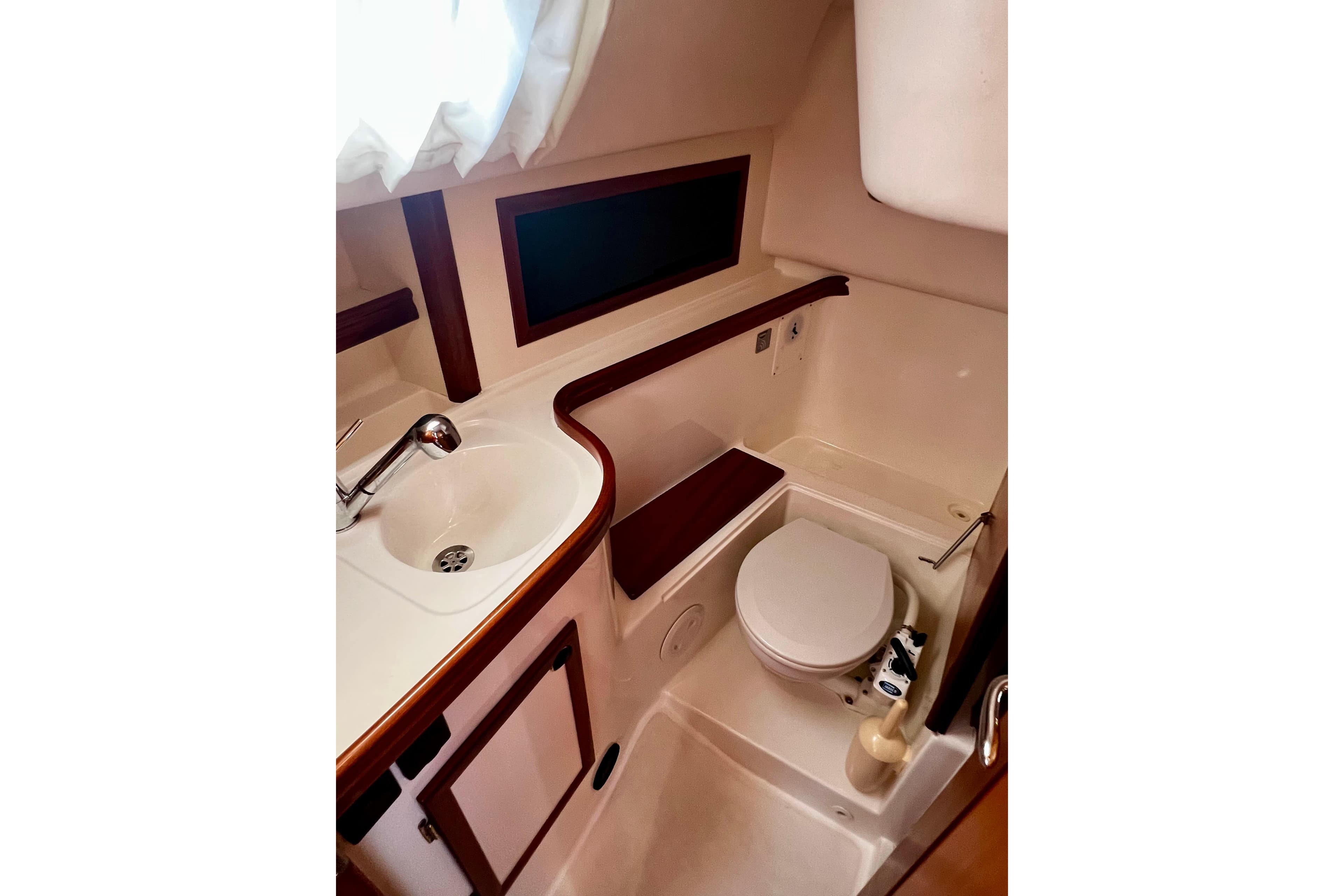 Compact bathroom in 2004 Adria Event 34 yacht with sink and toilet.