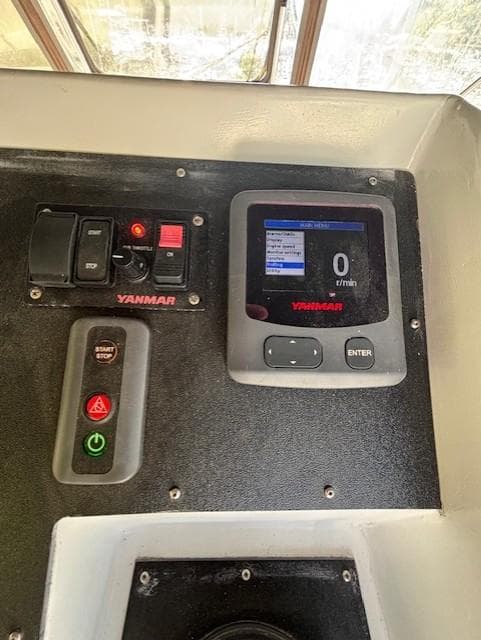 Control panel of a 1988 Riviera Convertible boat with Yanmar display and switches.