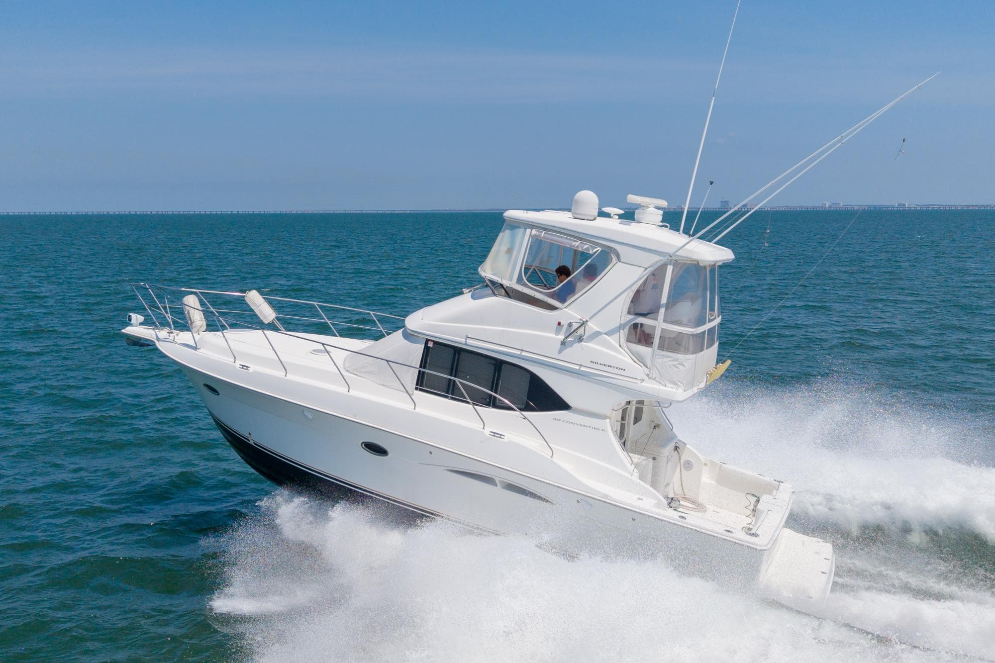 2007 Silverton 38 Convertible yacht cruising on open sea, creating waves.