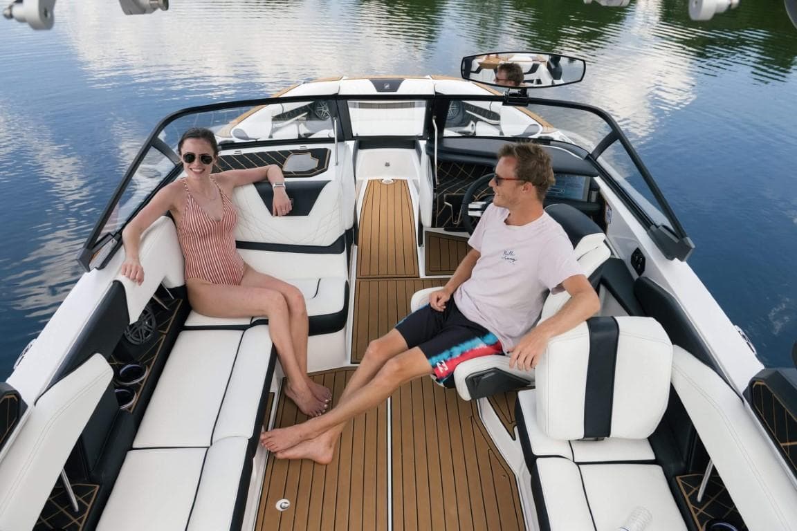 Couple relaxing on 2025 Ingenity GS22E electric boat, enjoying a sunny day on the water.