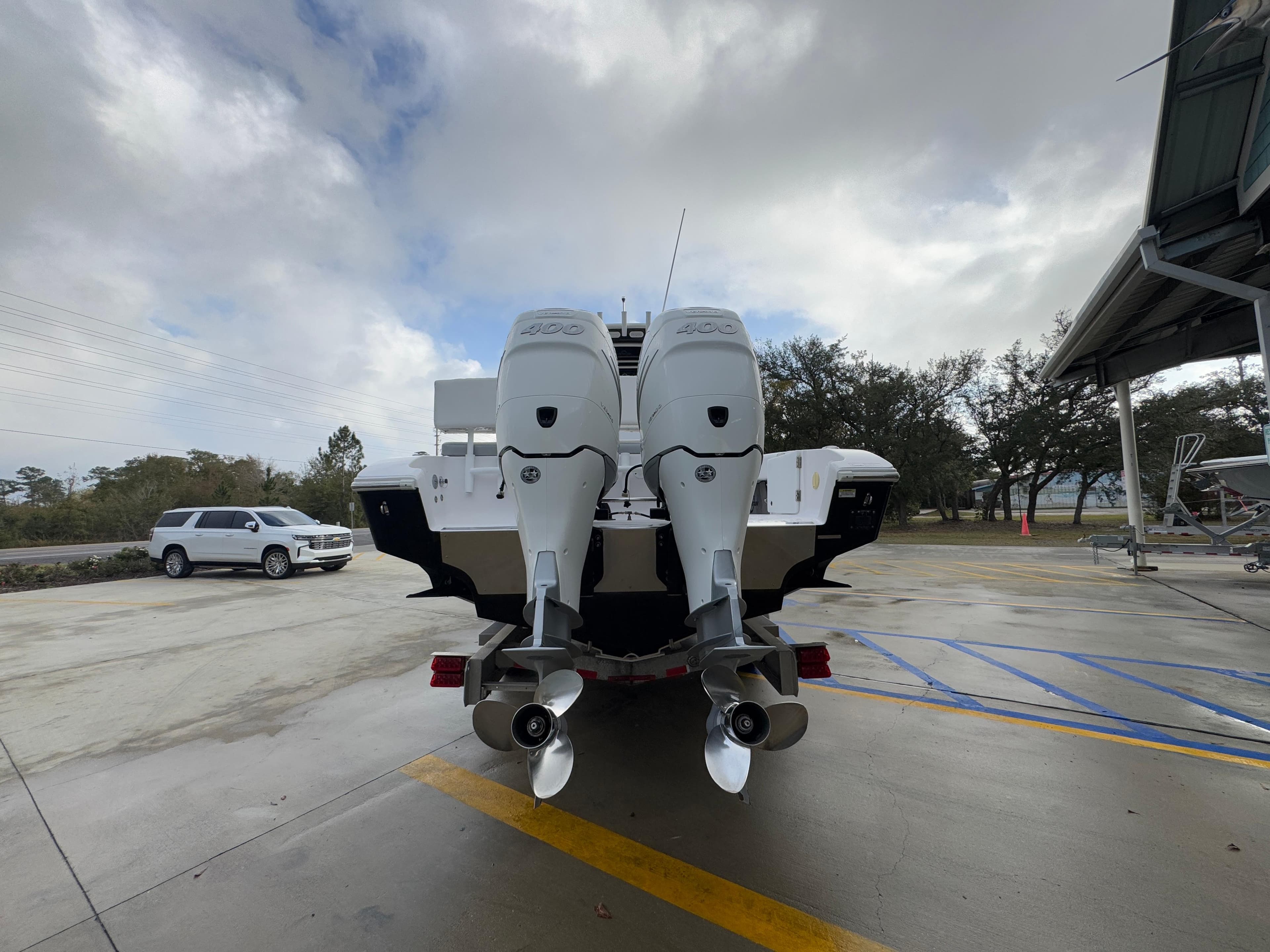 2018 Fountain 34 CC boat with dual outboard motors in a parking area.
