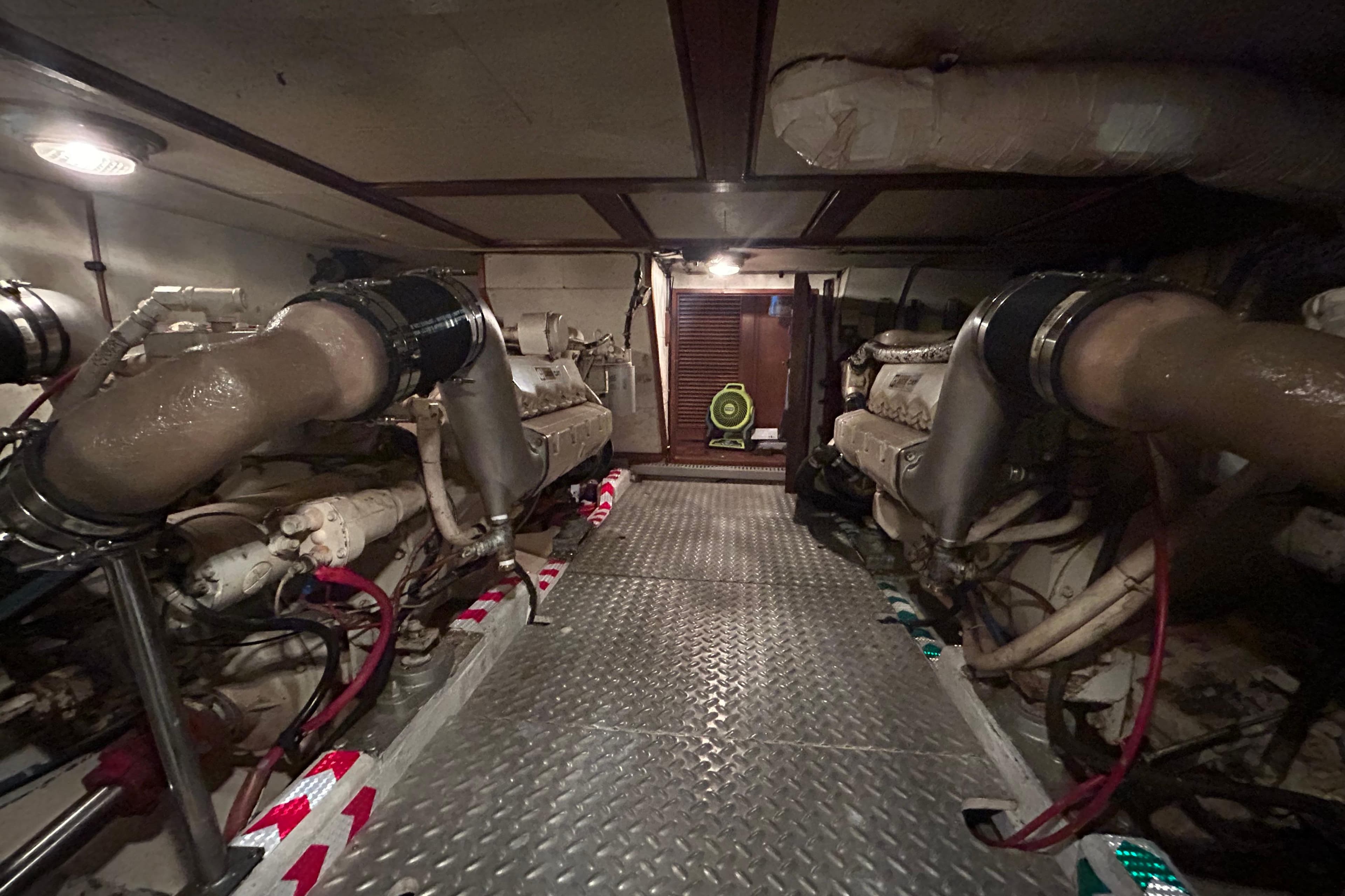 Engine room of 1981 Ocean Alexander 50 Pilothouse yacht with visible machinery and piping.