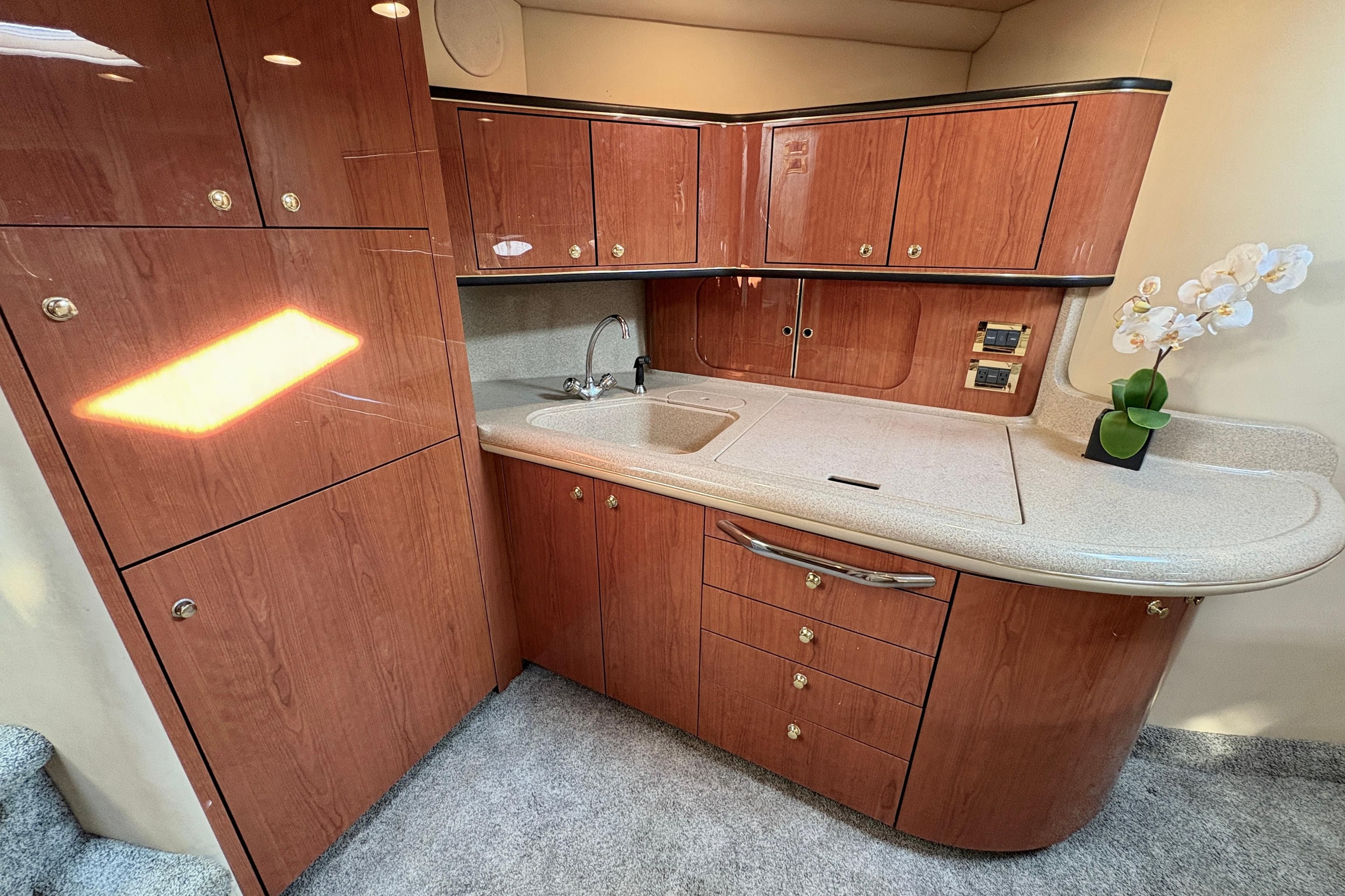 Luxurious 1999 Sea Ray 460 Sundancer yacht interior with elegant wood cabinetry and modern amenities.