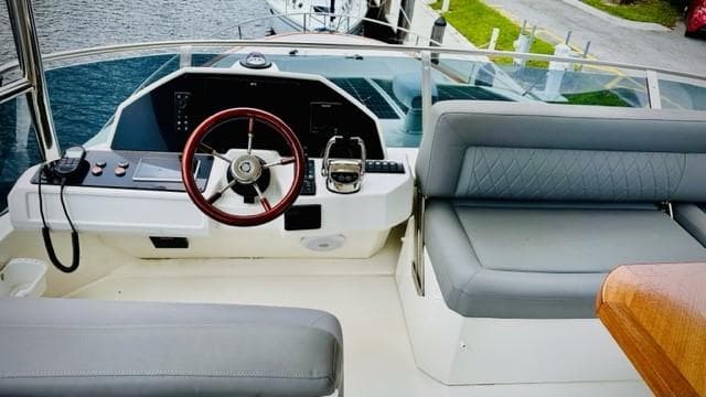 Flybridge helm of 2022 Greenline 48 with Hardtop, featuring modern controls and seating.