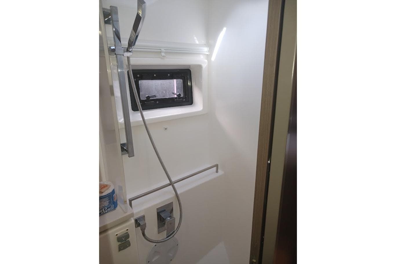 Modern shower area in 2022 Leopard 45 yacht with sleek fixtures and window.