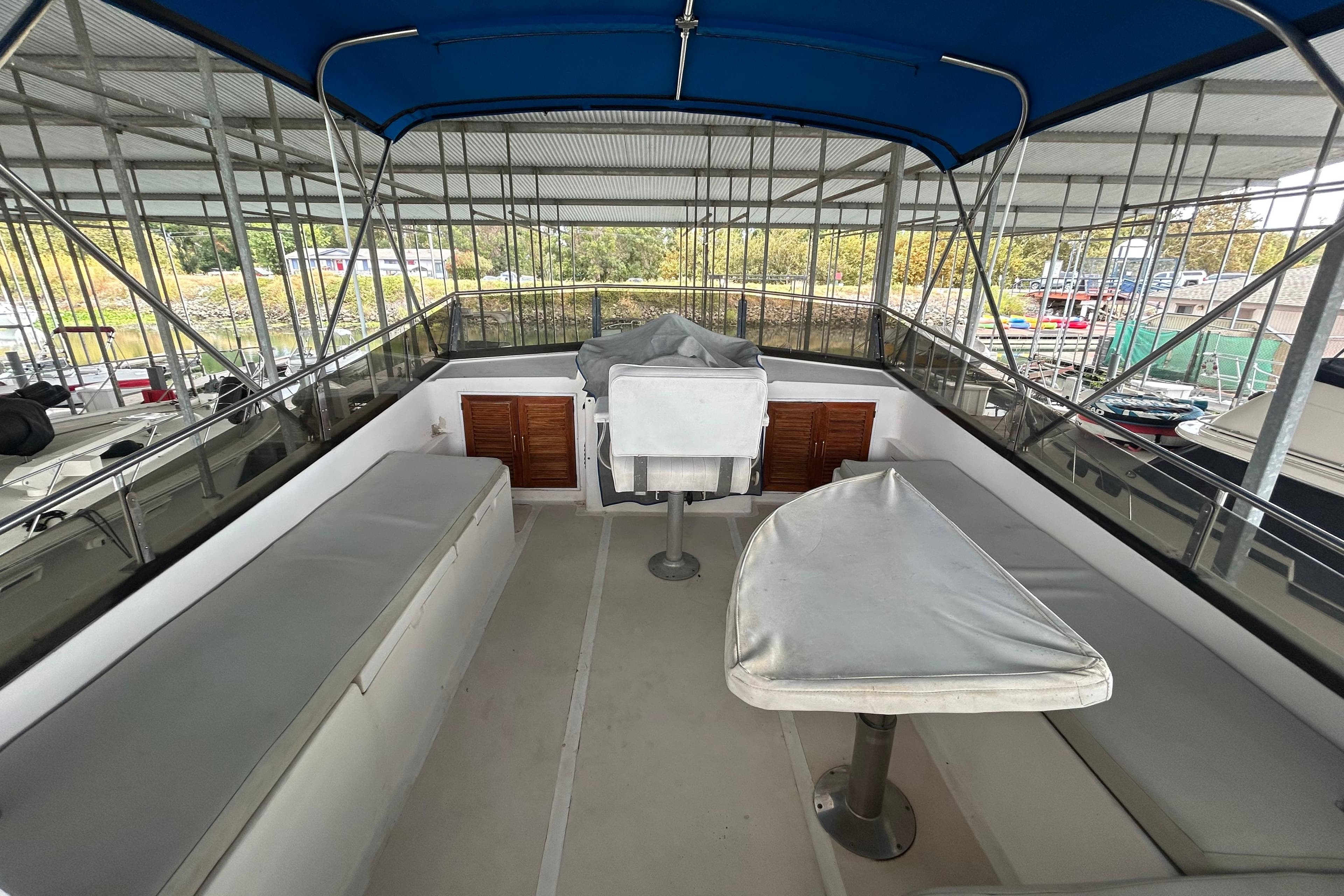 1988 CHB Ponderosa Motor Yacht interior with seating and covered table under blue canopy.