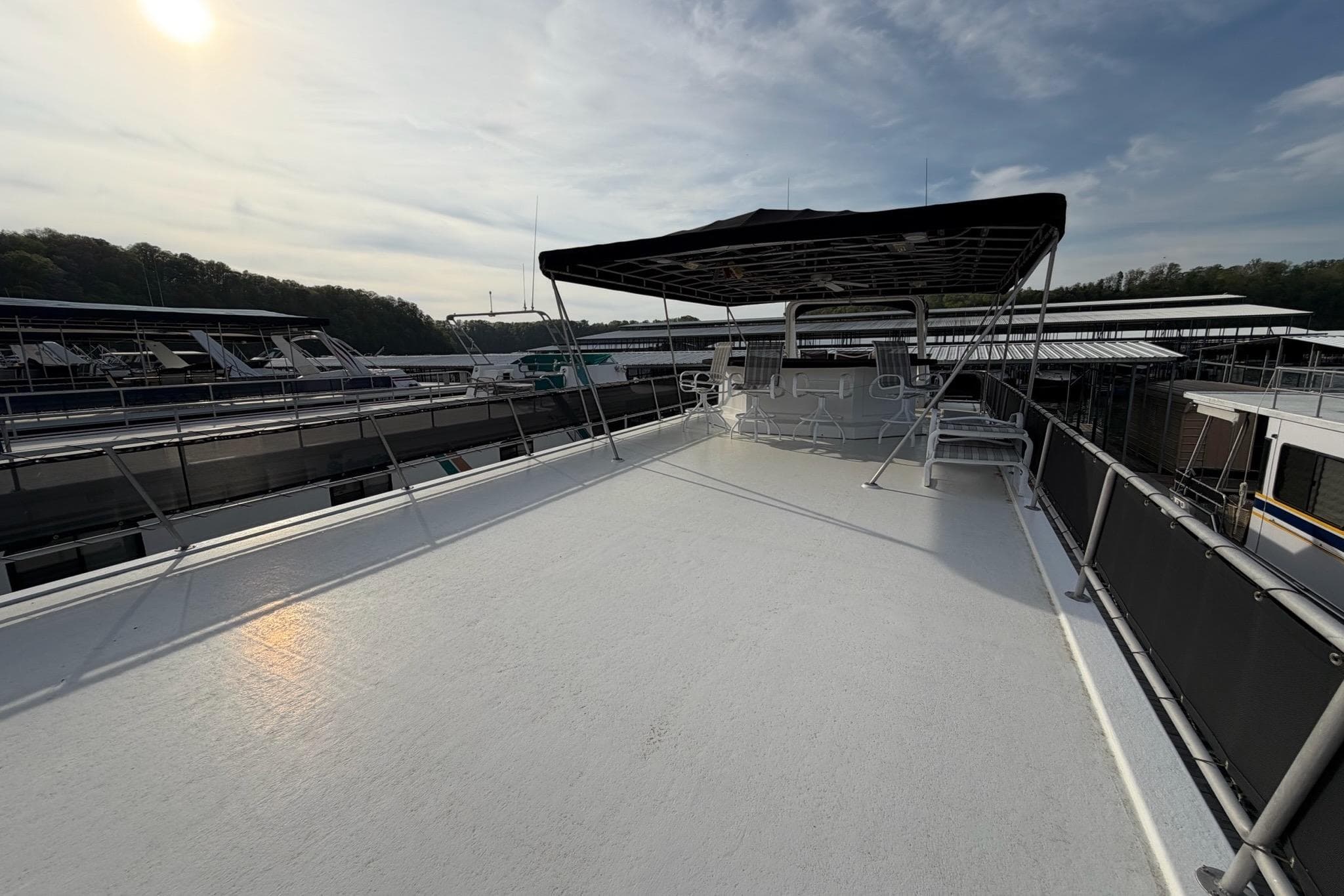 Sunstar 16x65 houseboat deck, 2000 model, docked under a clear sky.