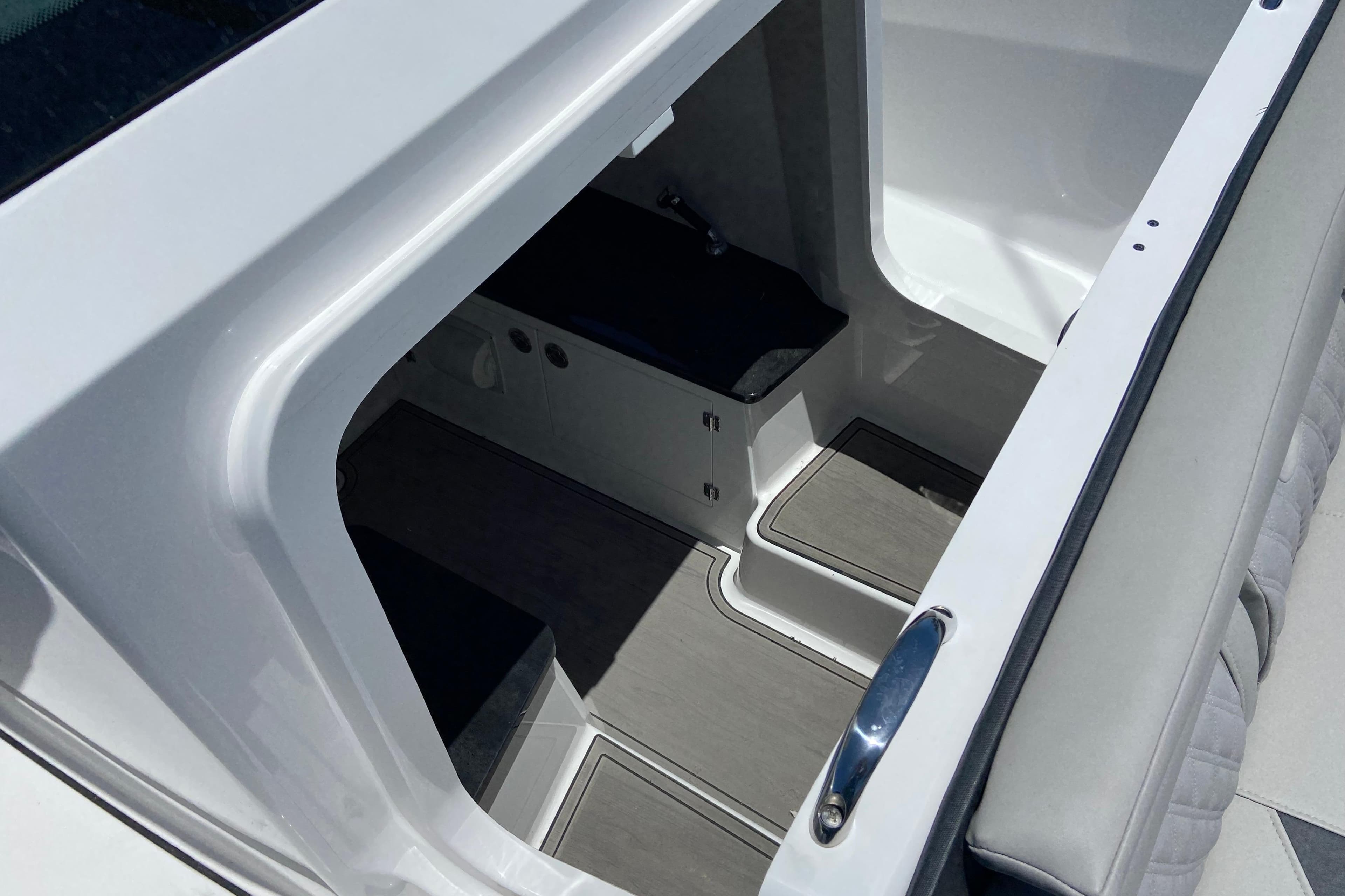 Interior view of 2026 Monterey Elite 25 OB boat, showcasing sleek design and storage space.