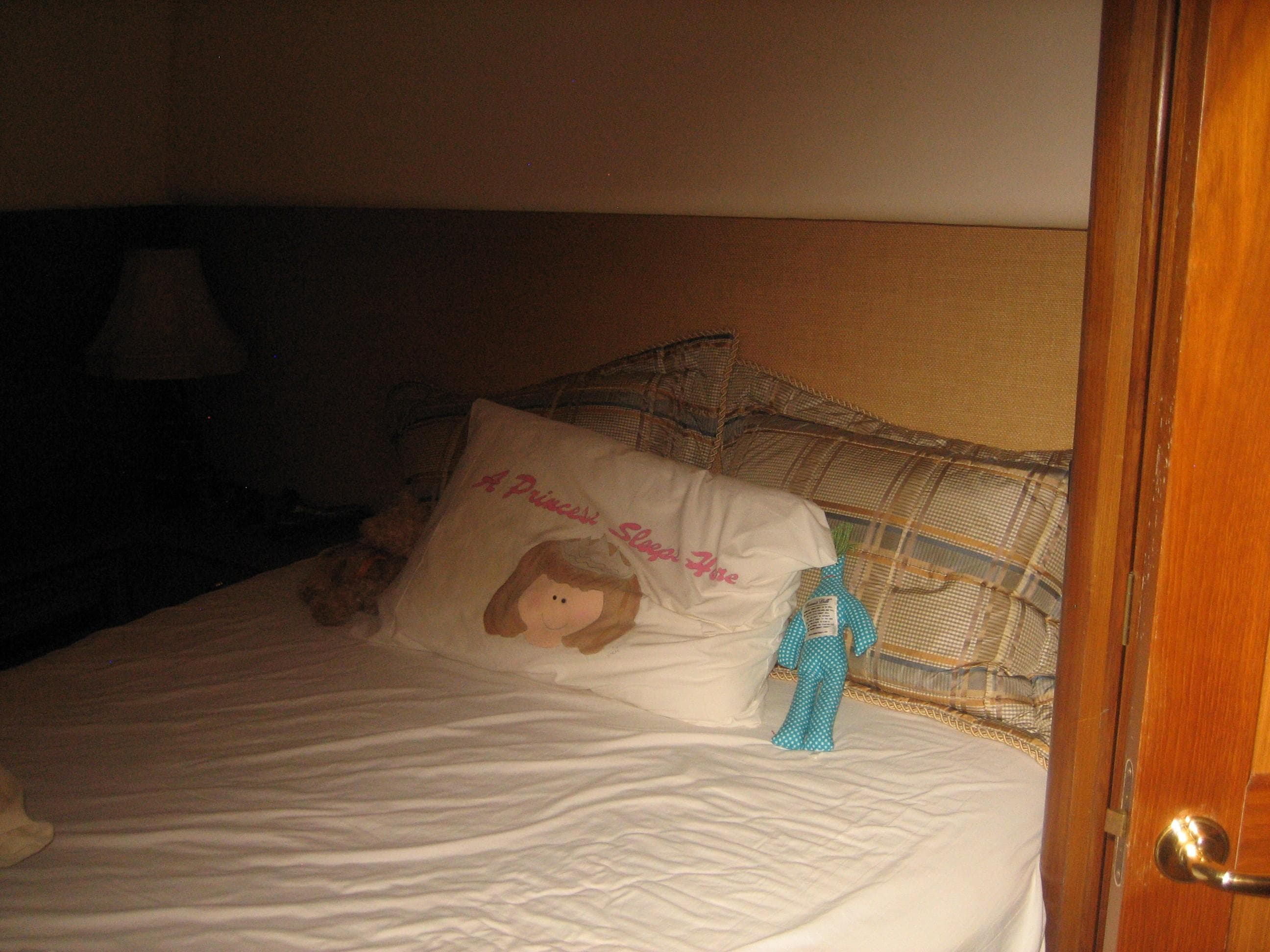 Cozy bedroom in 2005 Ocean Yachts 50 Super Sport with decorative pillows and soft lighting.